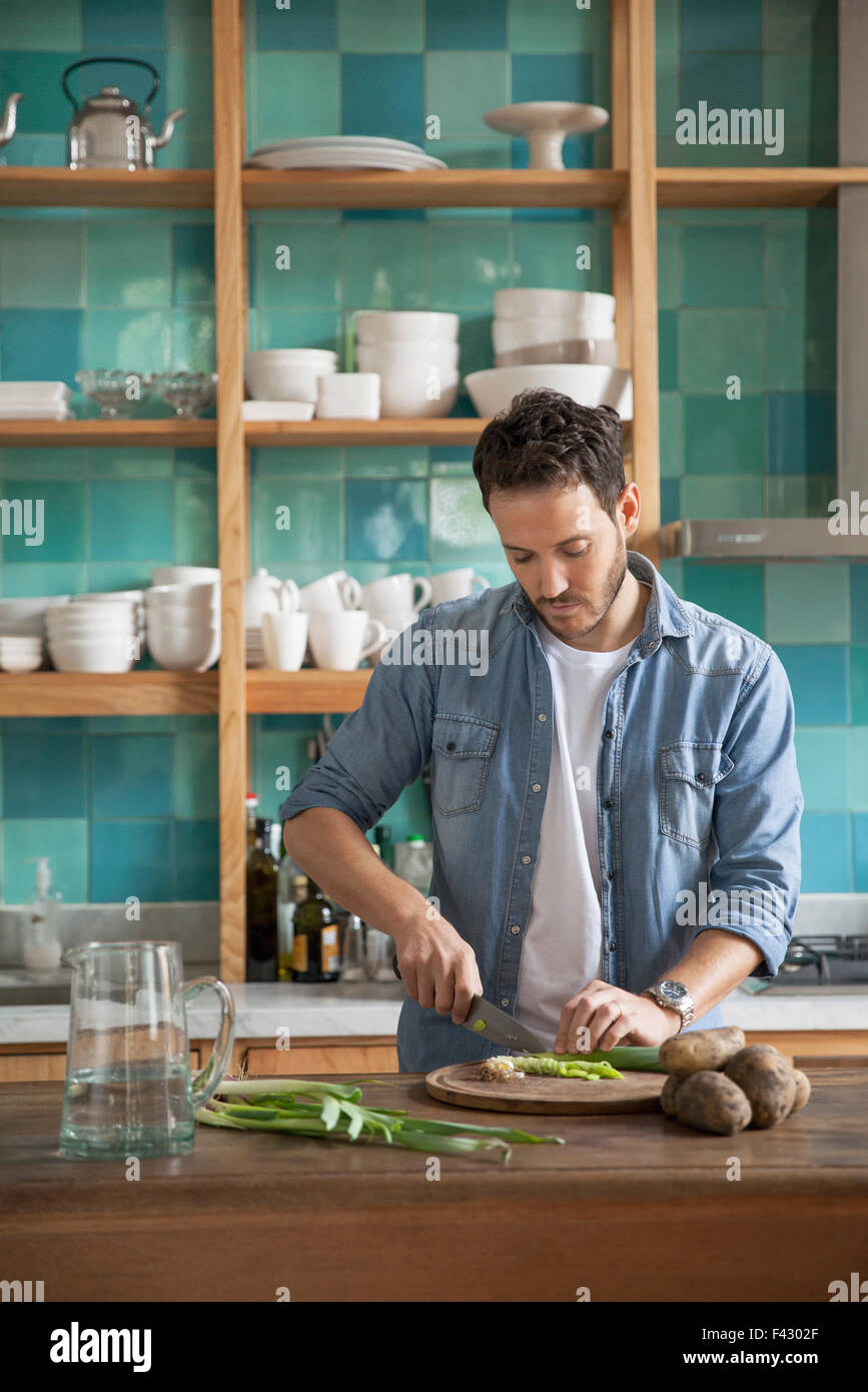 Man cutting ingredients in kitchen Stock Photo - Alamy