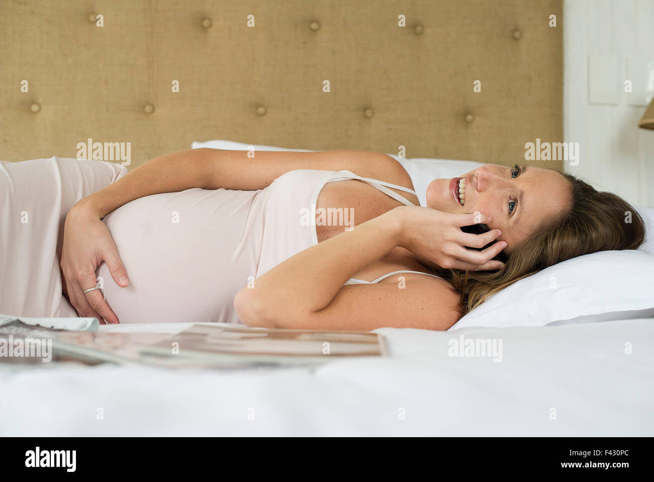 Pregnant woman using cell phone to stay in touch with friends and family Stock Photo