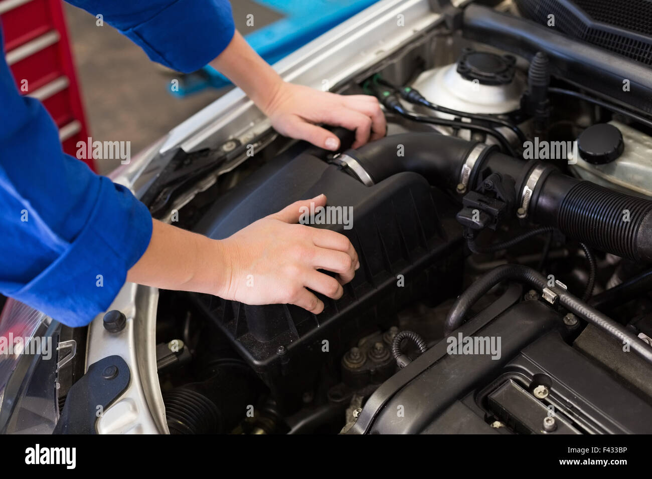 Mechanic examining under hood of car Stock Photo Alamy