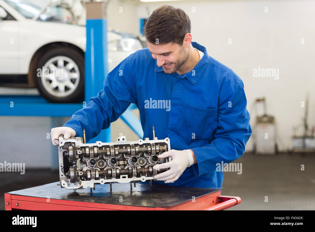 Smiling mechanic working on engine Stock Photo Alamy
