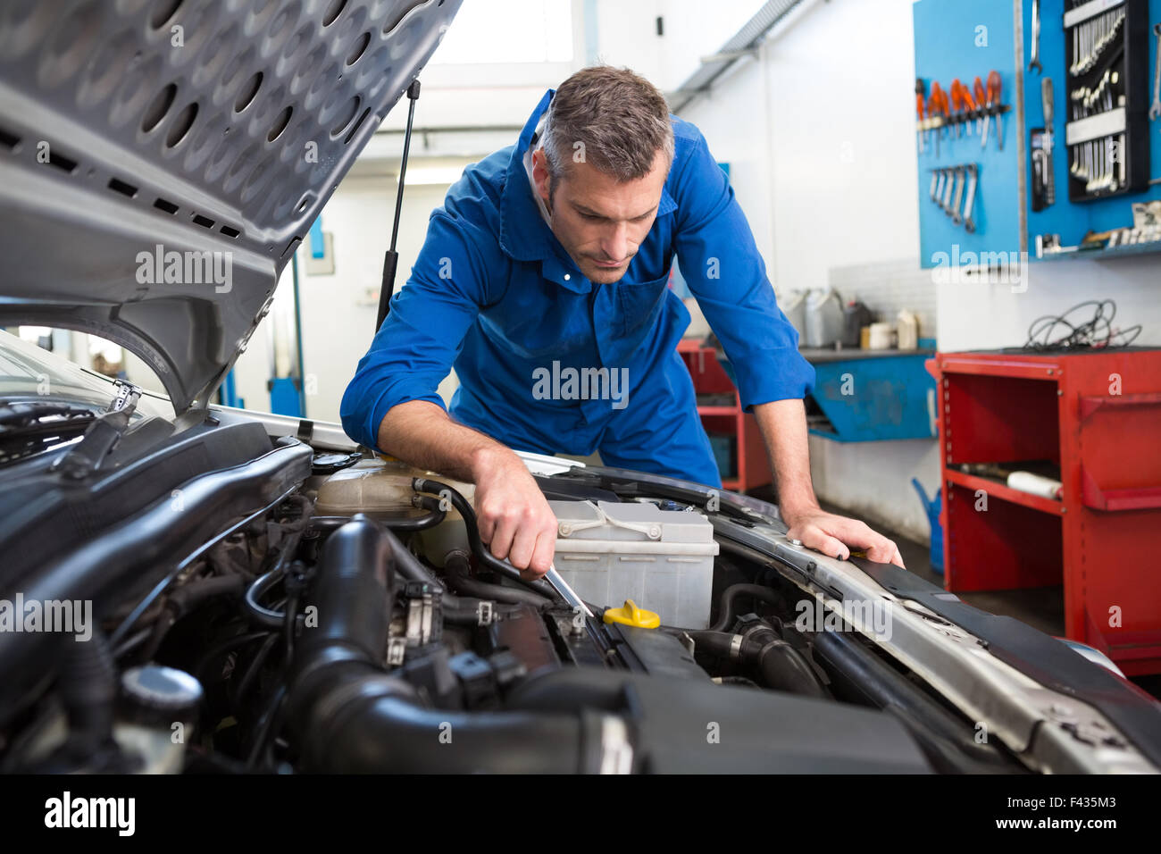 Mechanic examining under hood of car Stock Photo Alamy