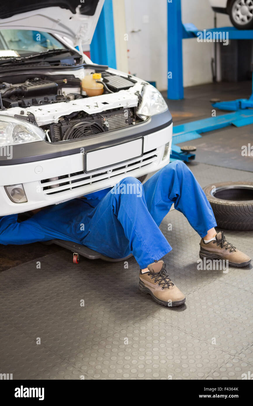 Mechanic lying and working under car Stock Photo Alamy