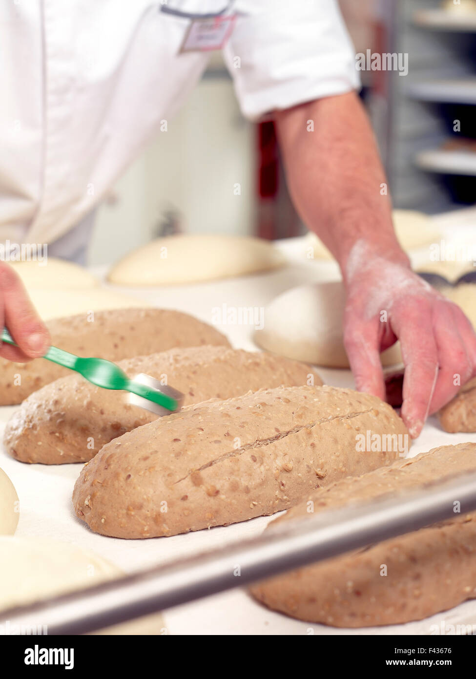 Baker scoring bread dough, cropped Stock Photo