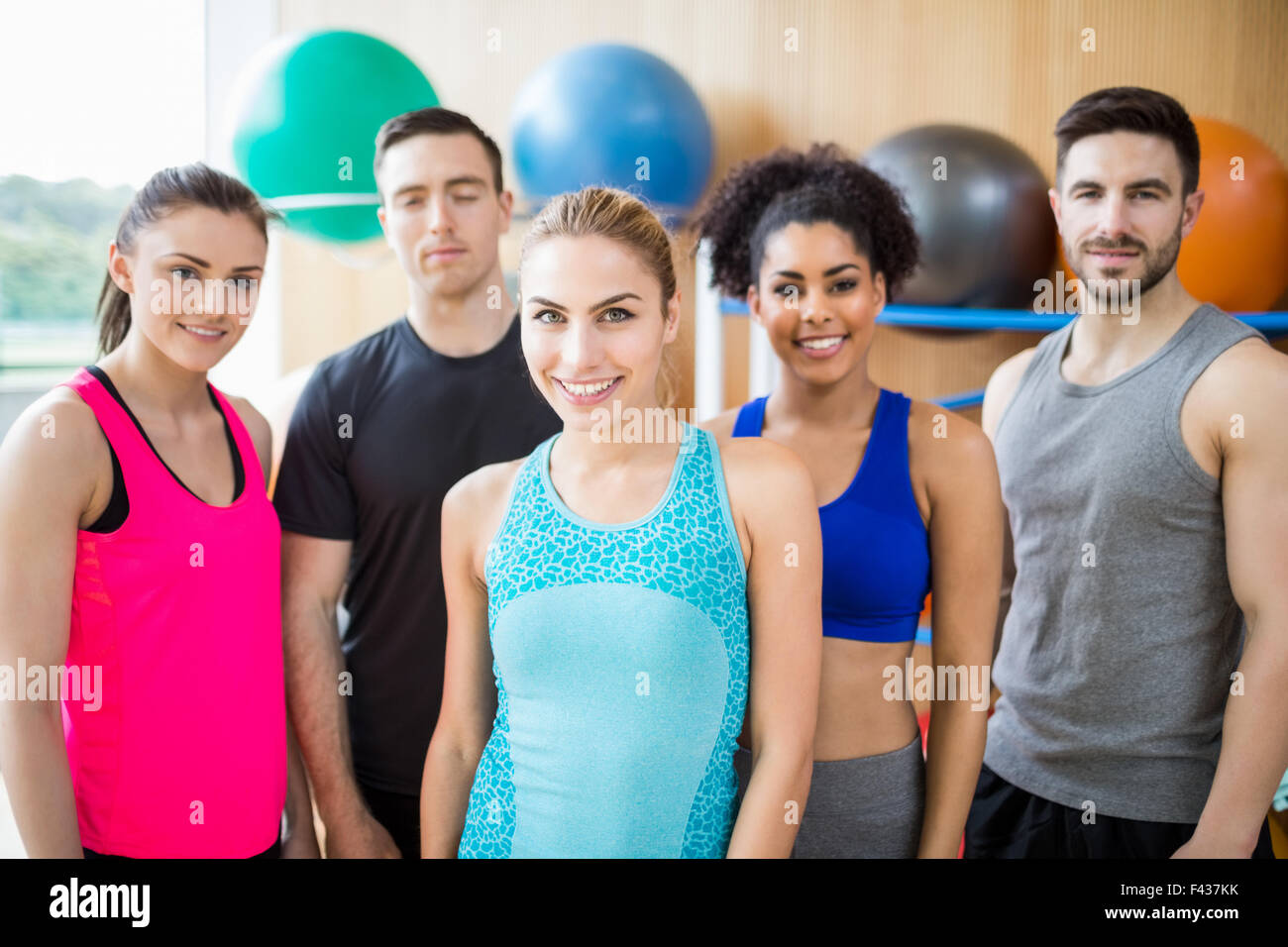 Fitness class smiling at camera in studio Stock Photo - Alamy
