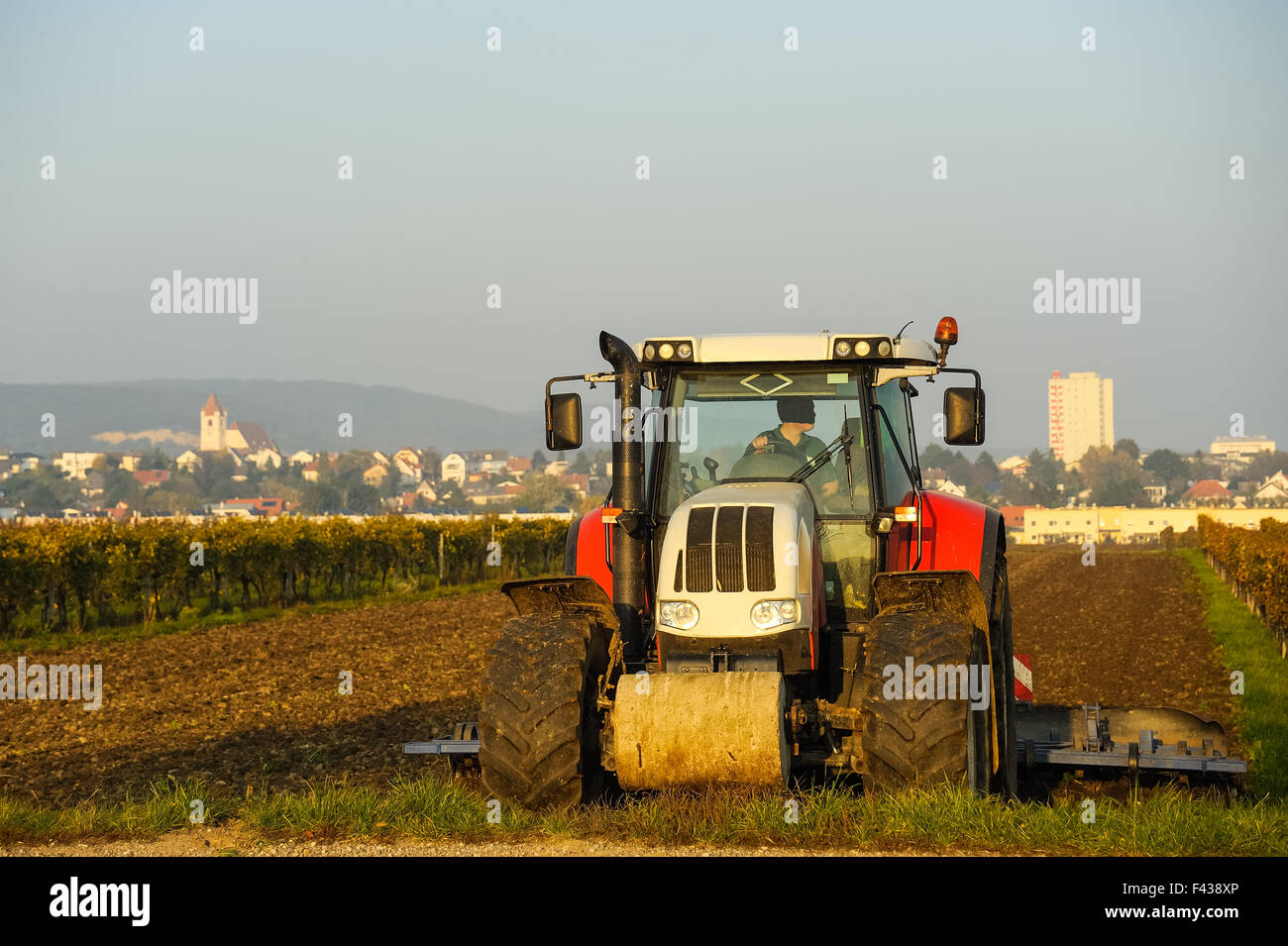Tractor harrowing on the field Stock Photo - Alamy