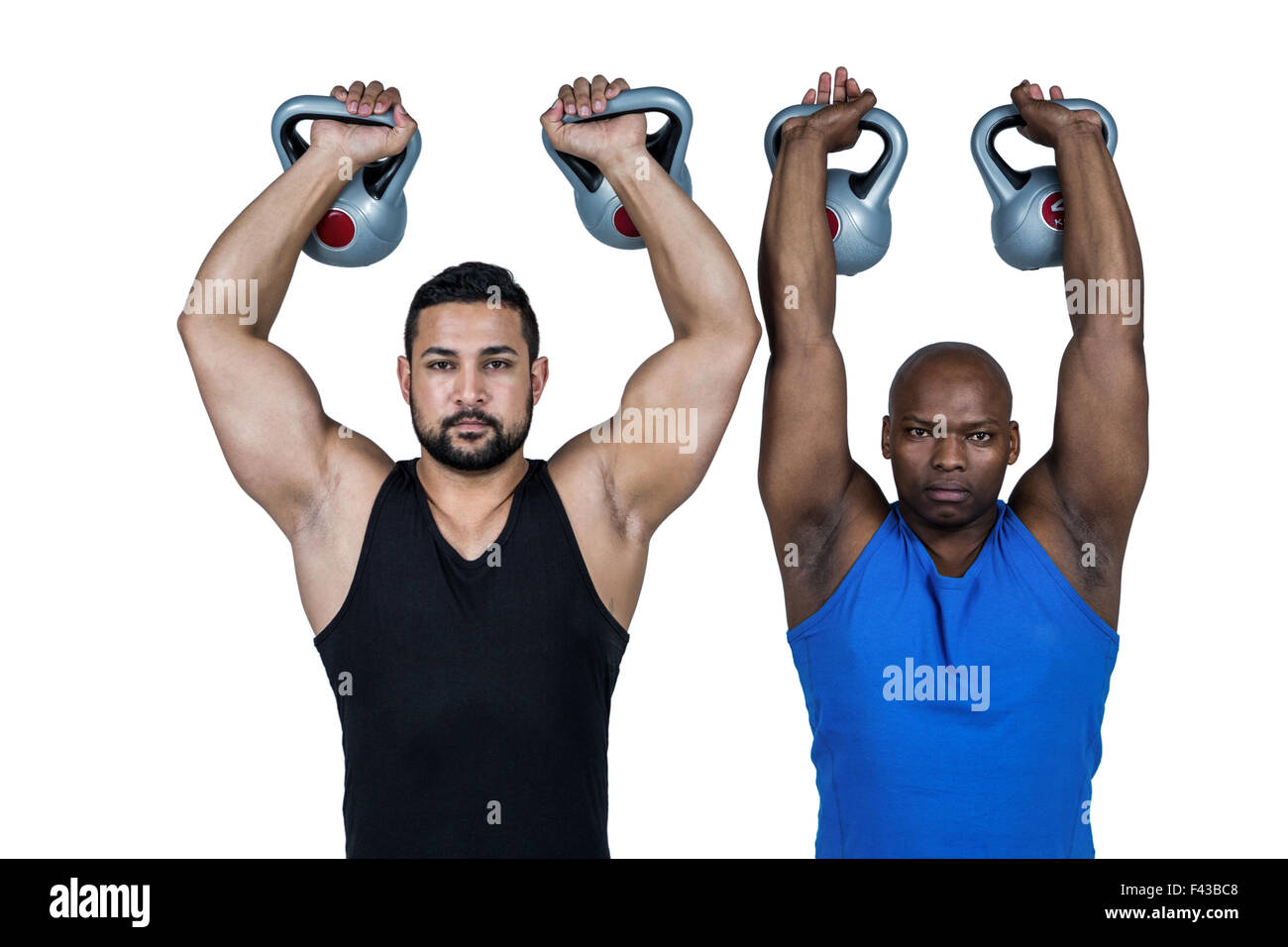 Strong friends lifting kettlebells together Stock Photo