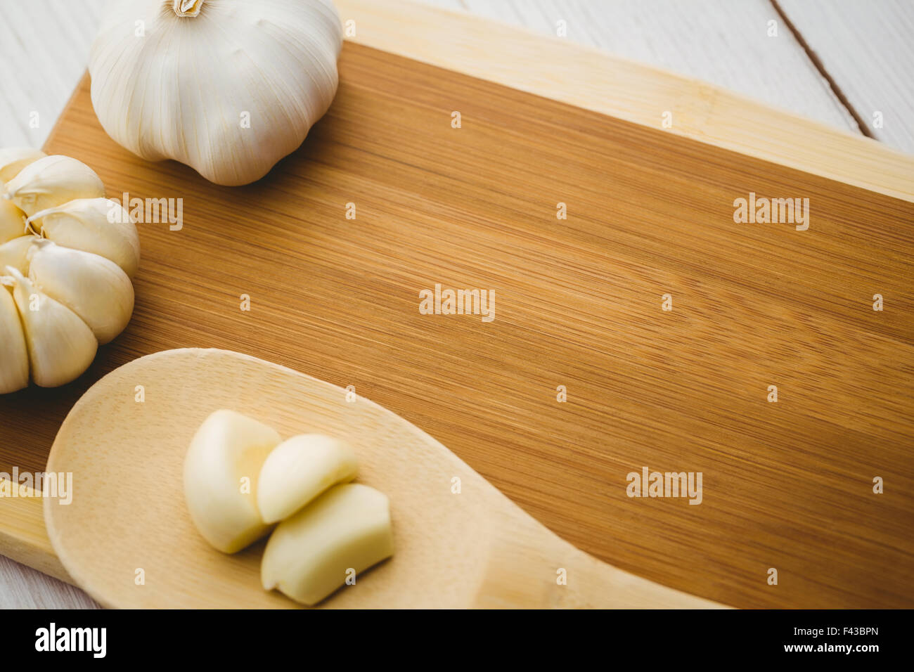 Garlic cloves and bulb on chopping board Stock Photo - Alamy