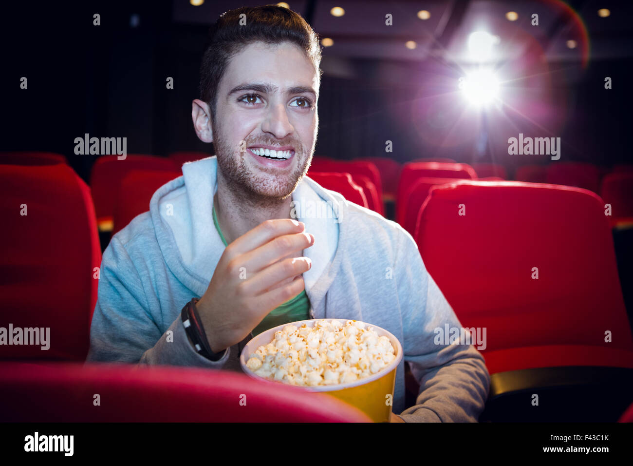 Young man watching a film Stock Photo - Alamy