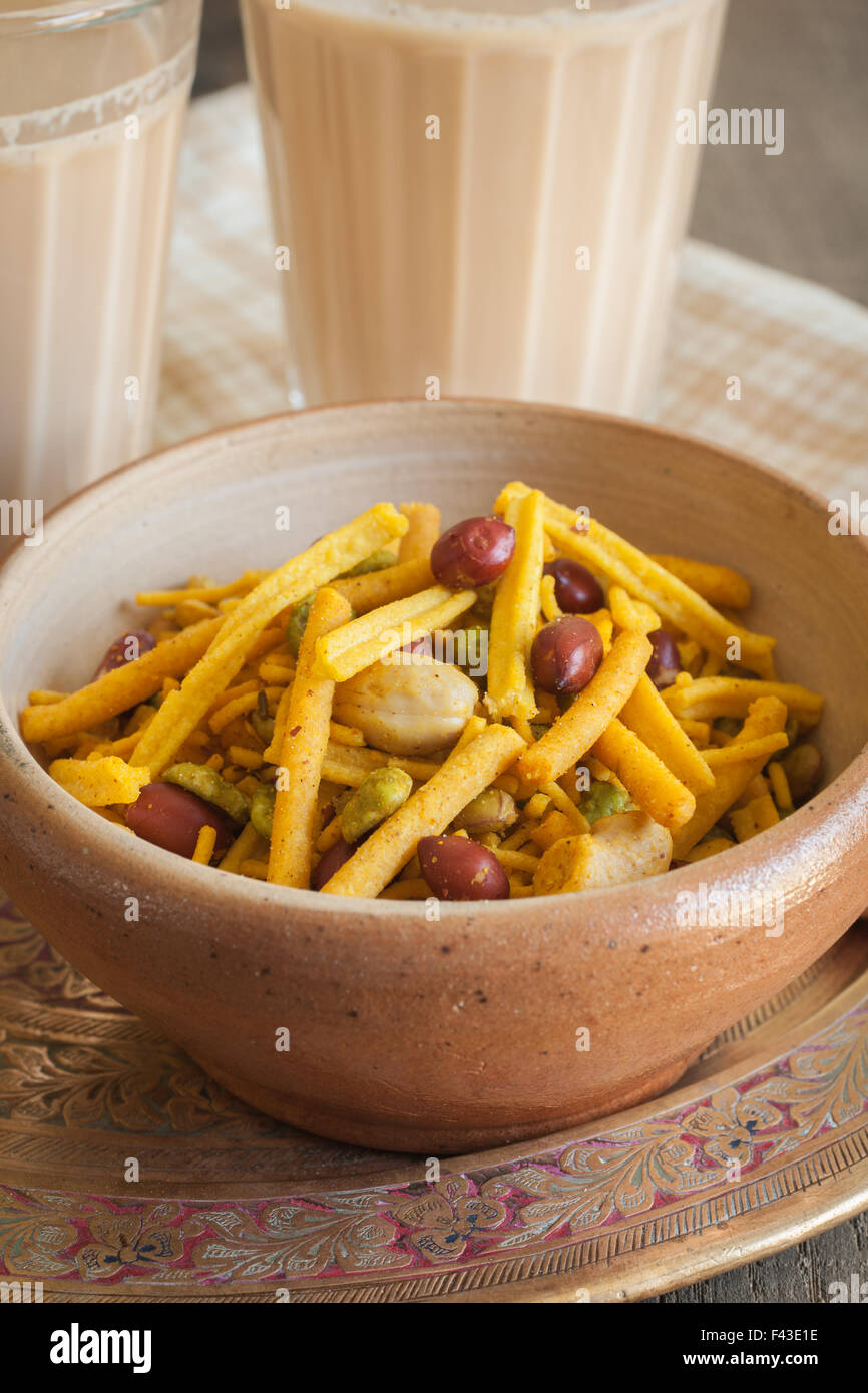 A bowl of spicy Bombay Mix served with Indian Masala chai tea Stock Photo