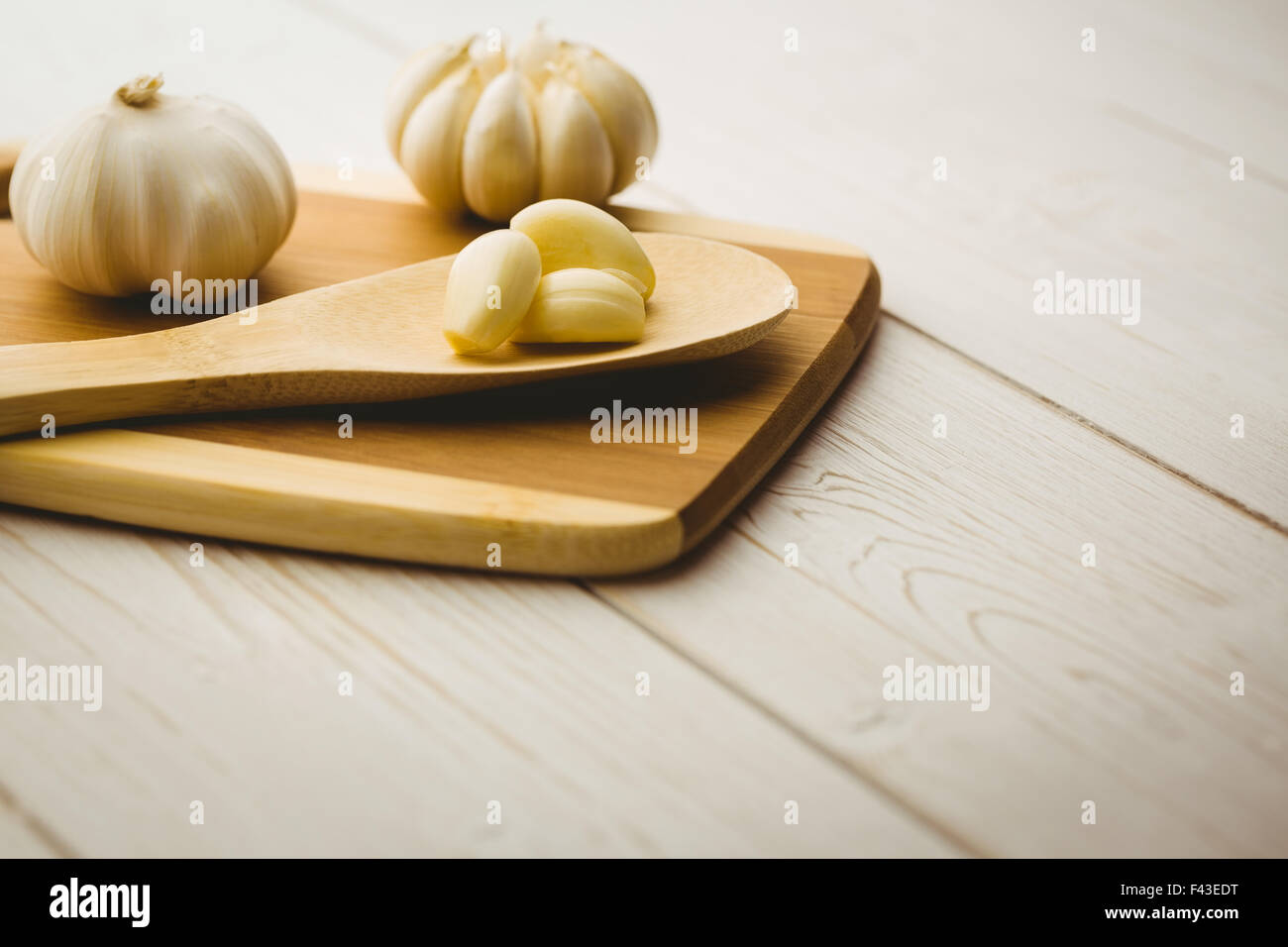 Garlic cloves and bulb on chopping board Stock Photo - Alamy