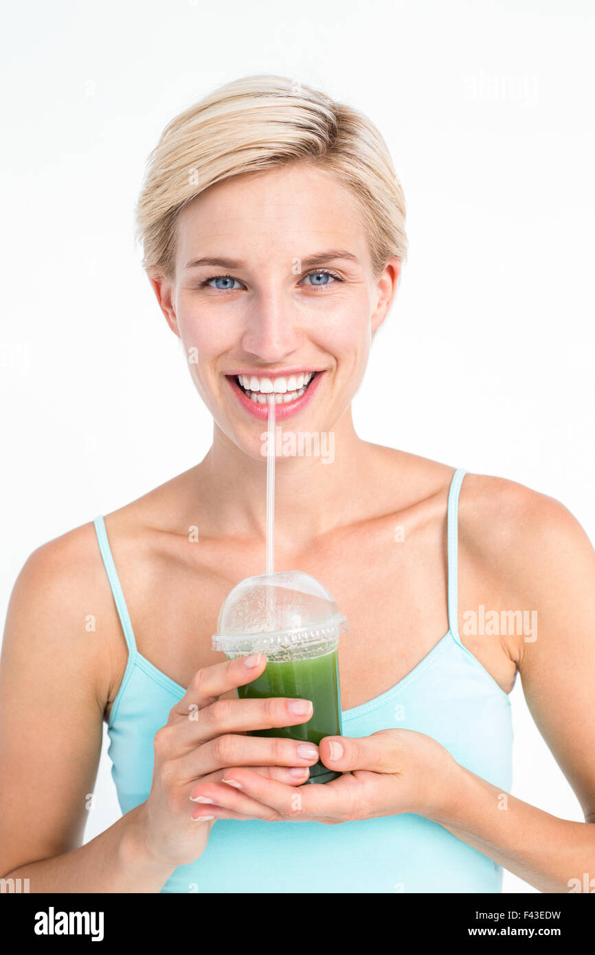 Attractive blonde drinking green juice Stock Photo Alamy