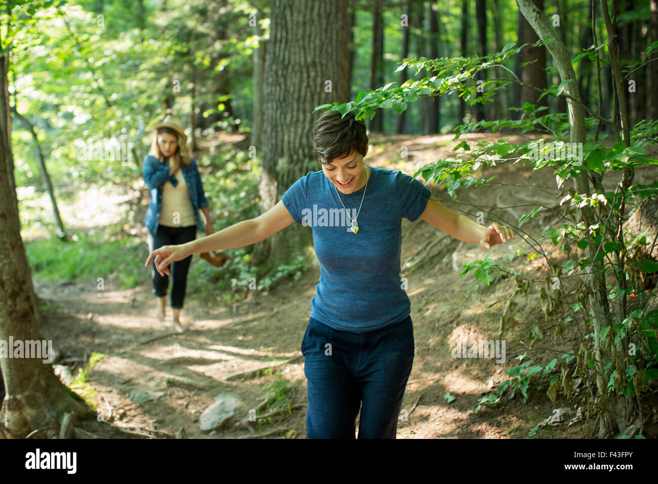 Two women walking down a woodland path. Stock Photo