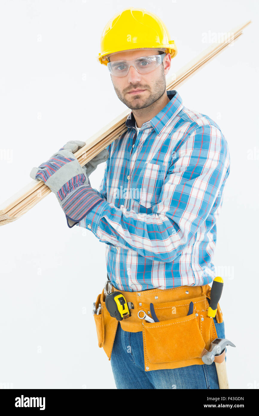 Construction worker carrying wooden planks Stock Photo - Alamy