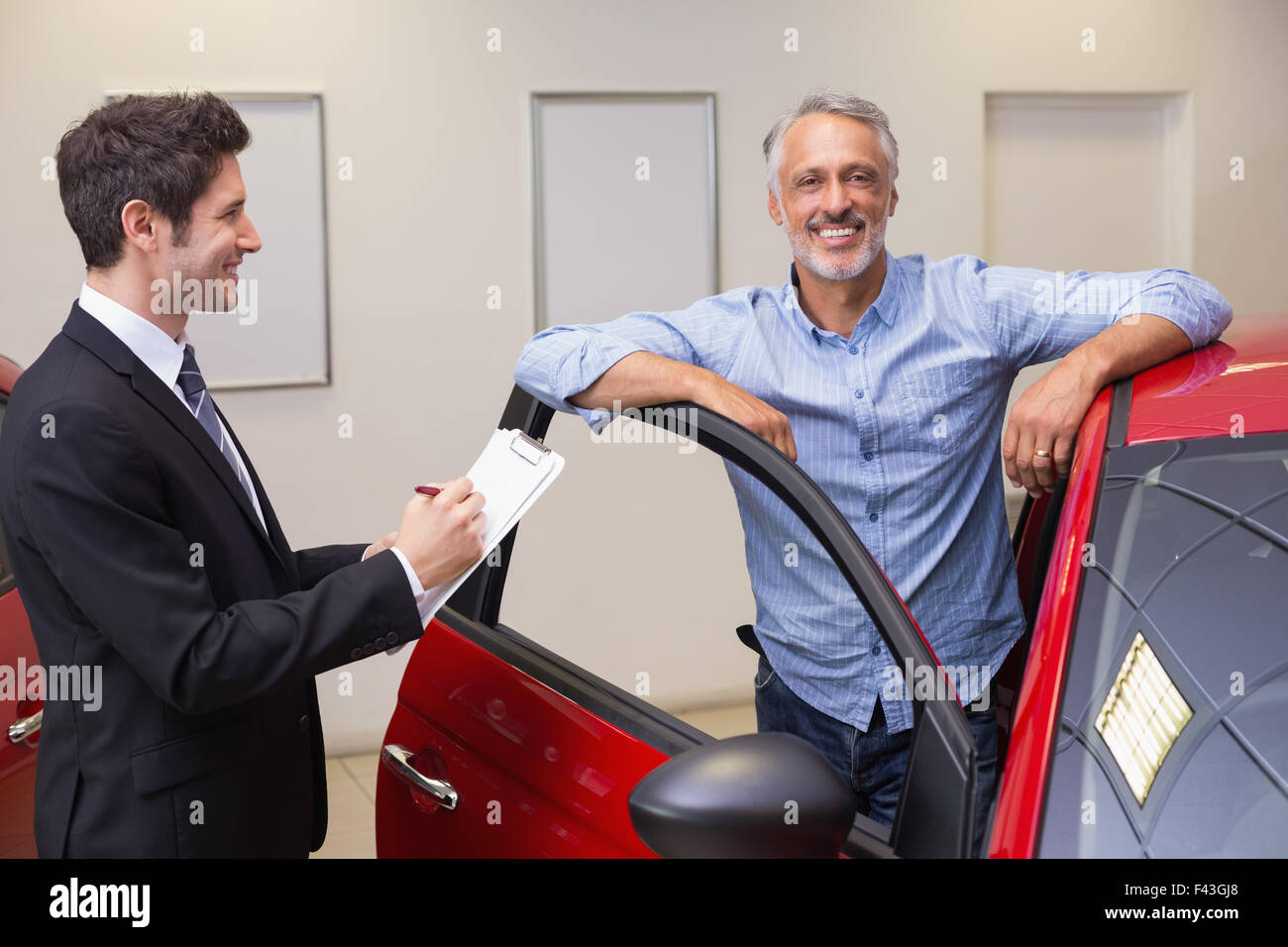 Smiling businessman writing on clipboard Stock Photo - Alamy