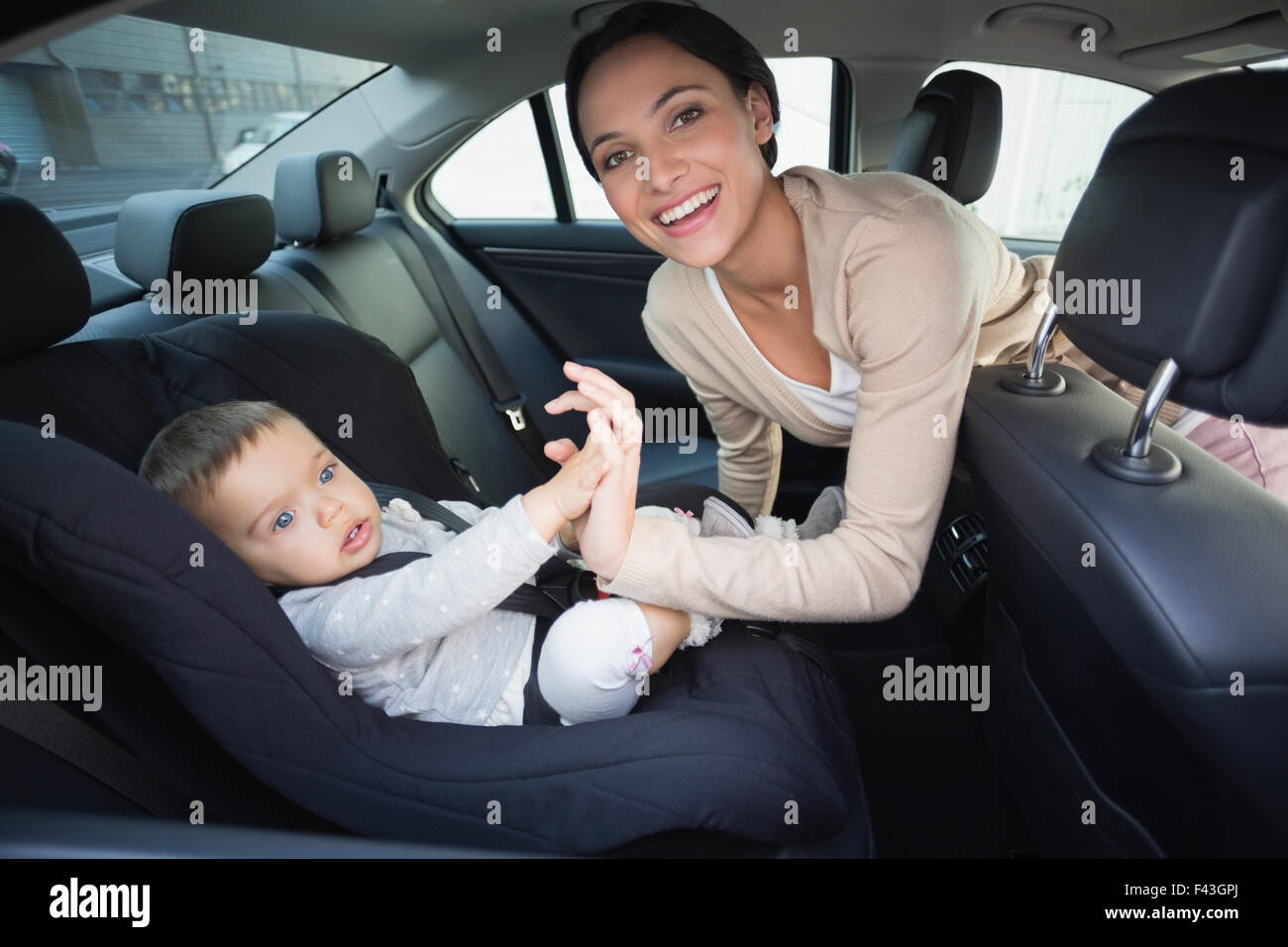 Mother securing her baby in the car seat Stock Photo - Alamy