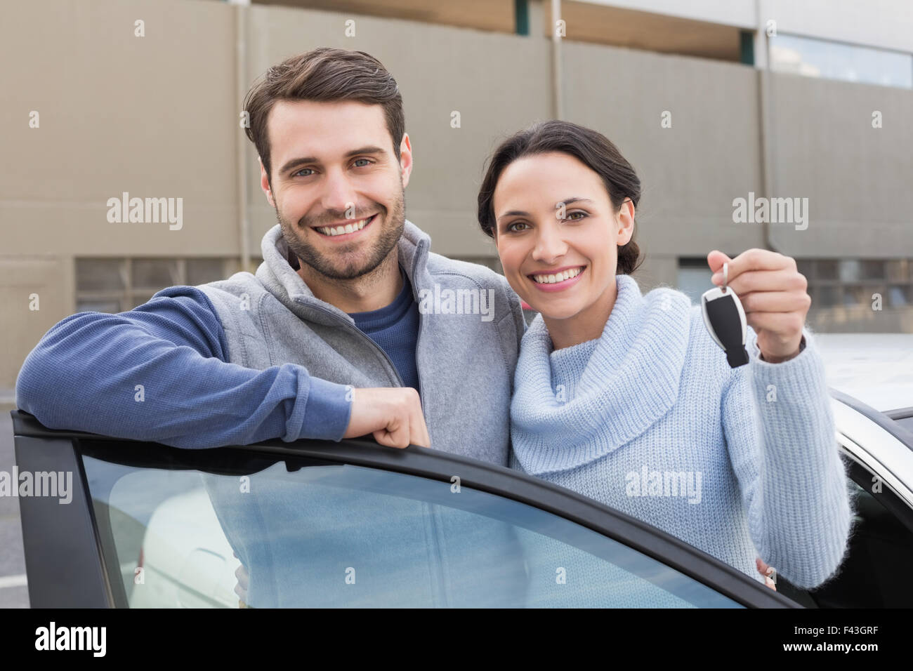Young couple smiling holding new key Stock Photo - Alamy