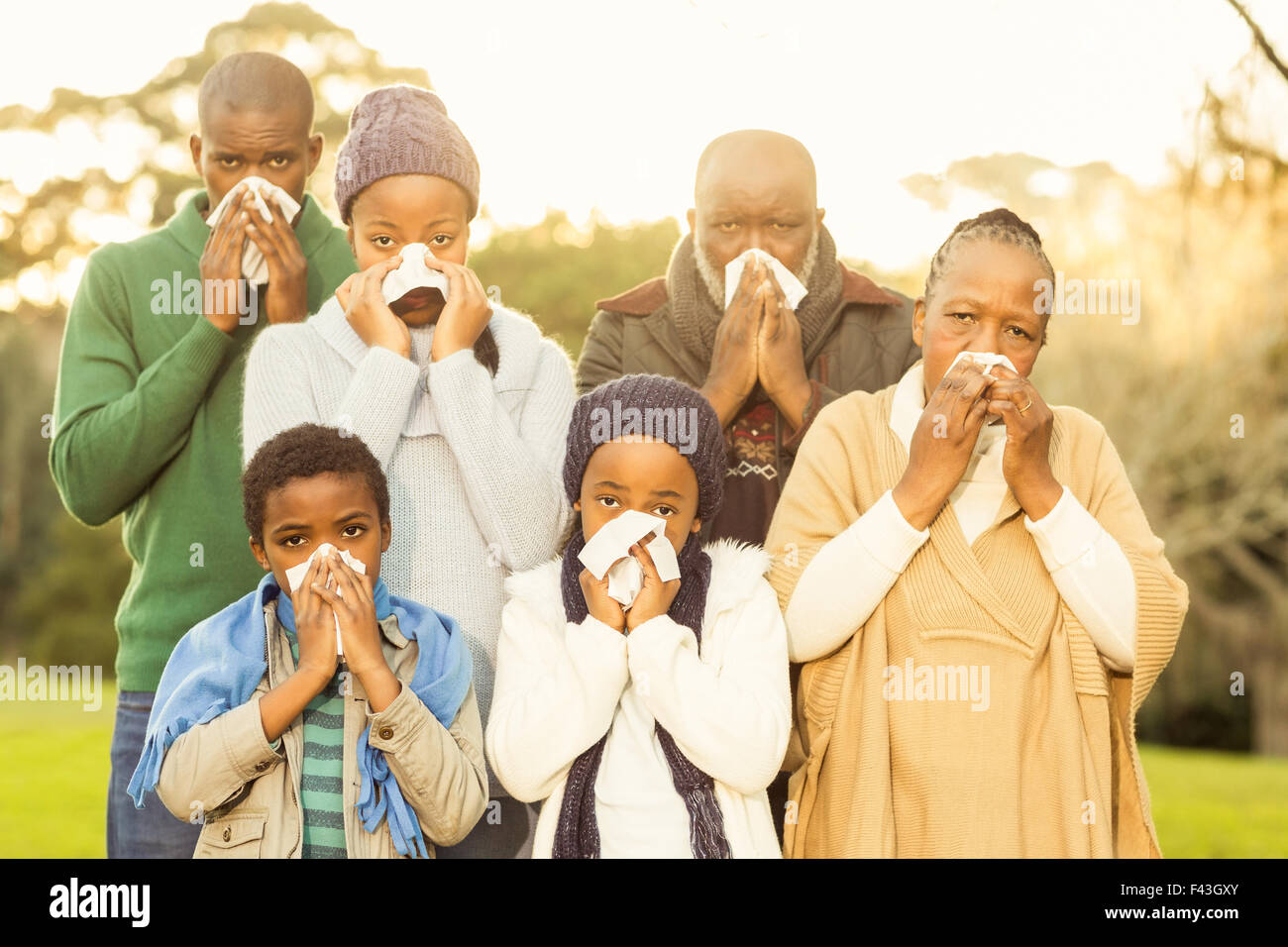 Extended family blowing their nose Stock Photo