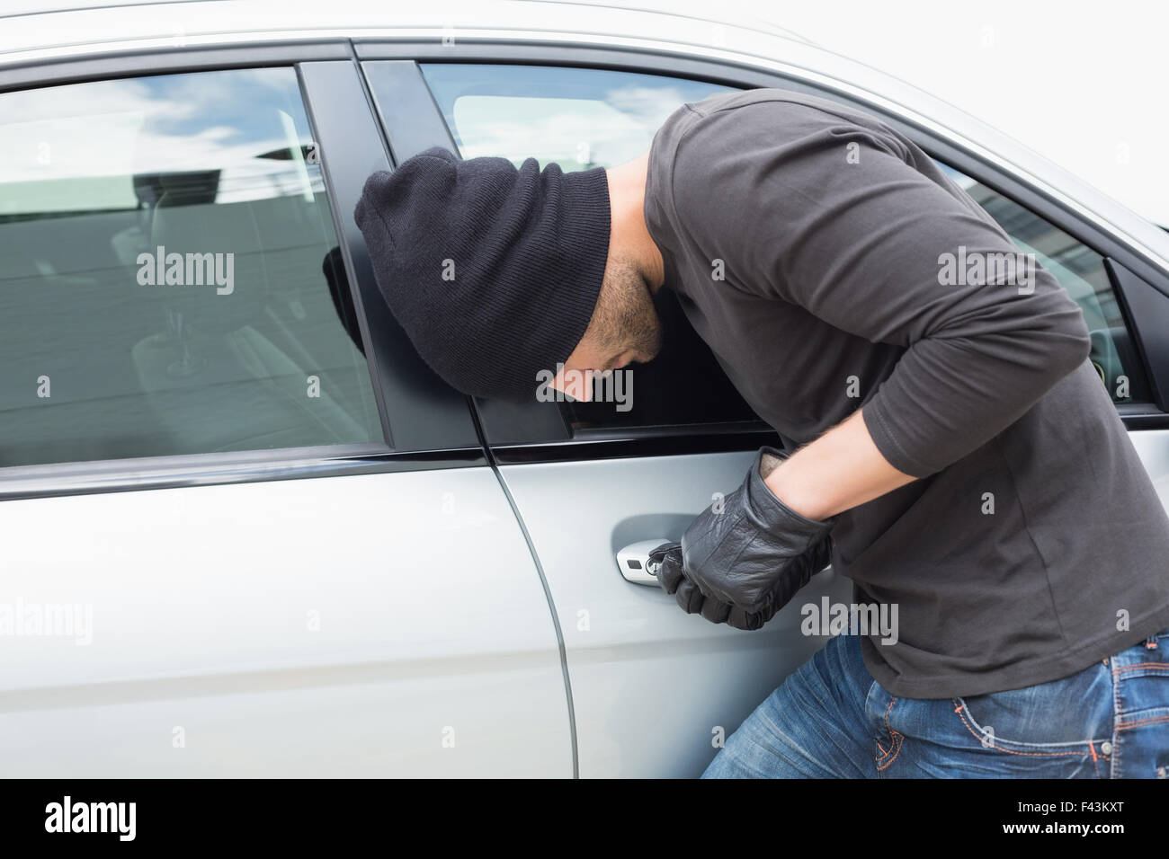 Thief breaking into a car Stock Photo Alamy