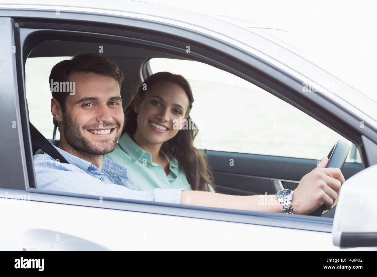 Young couple smiling at the camera Stock Photo - Alamy