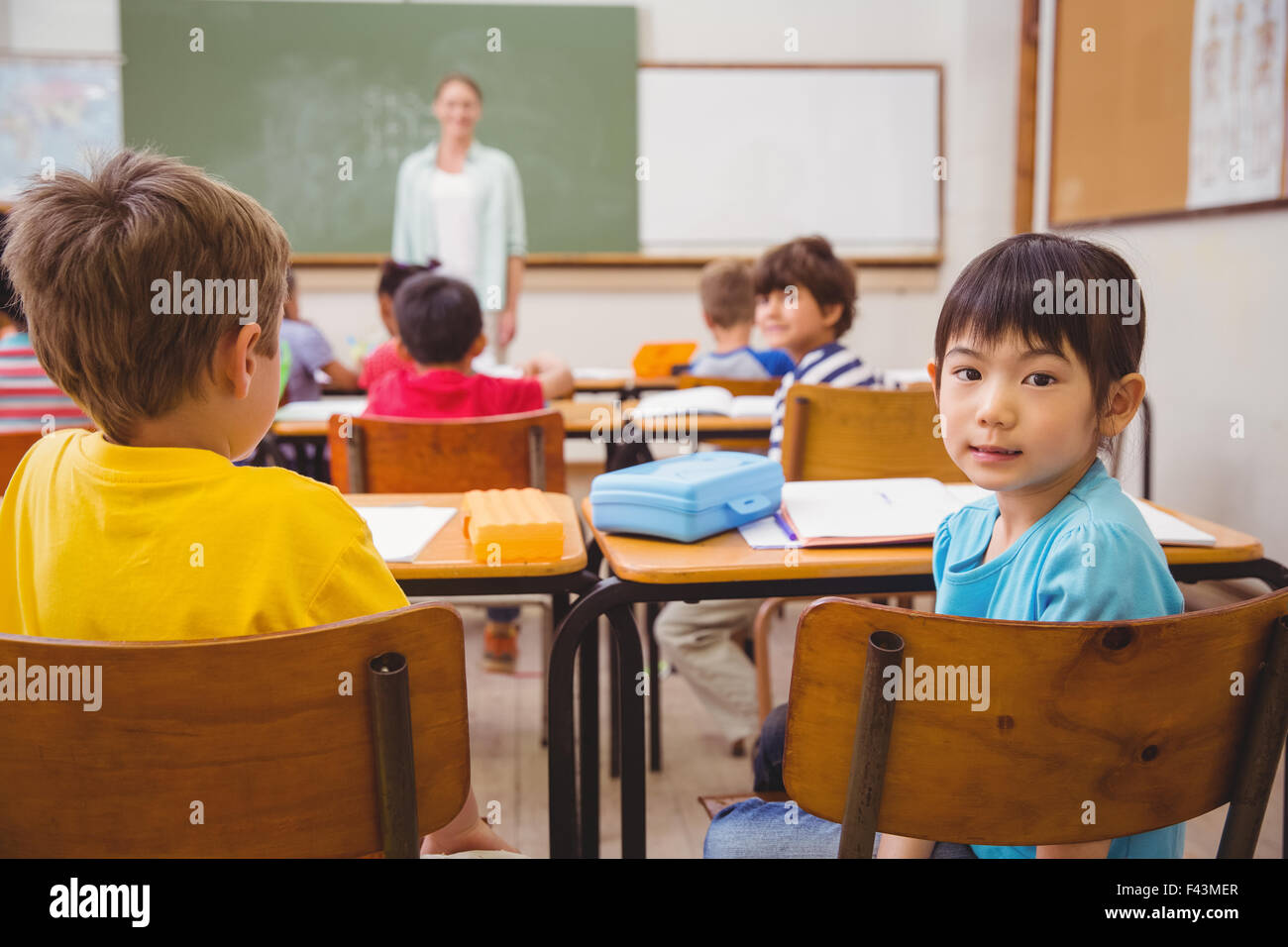 Cute pupil smiling at camera in classroom Stock Photo - Alamy