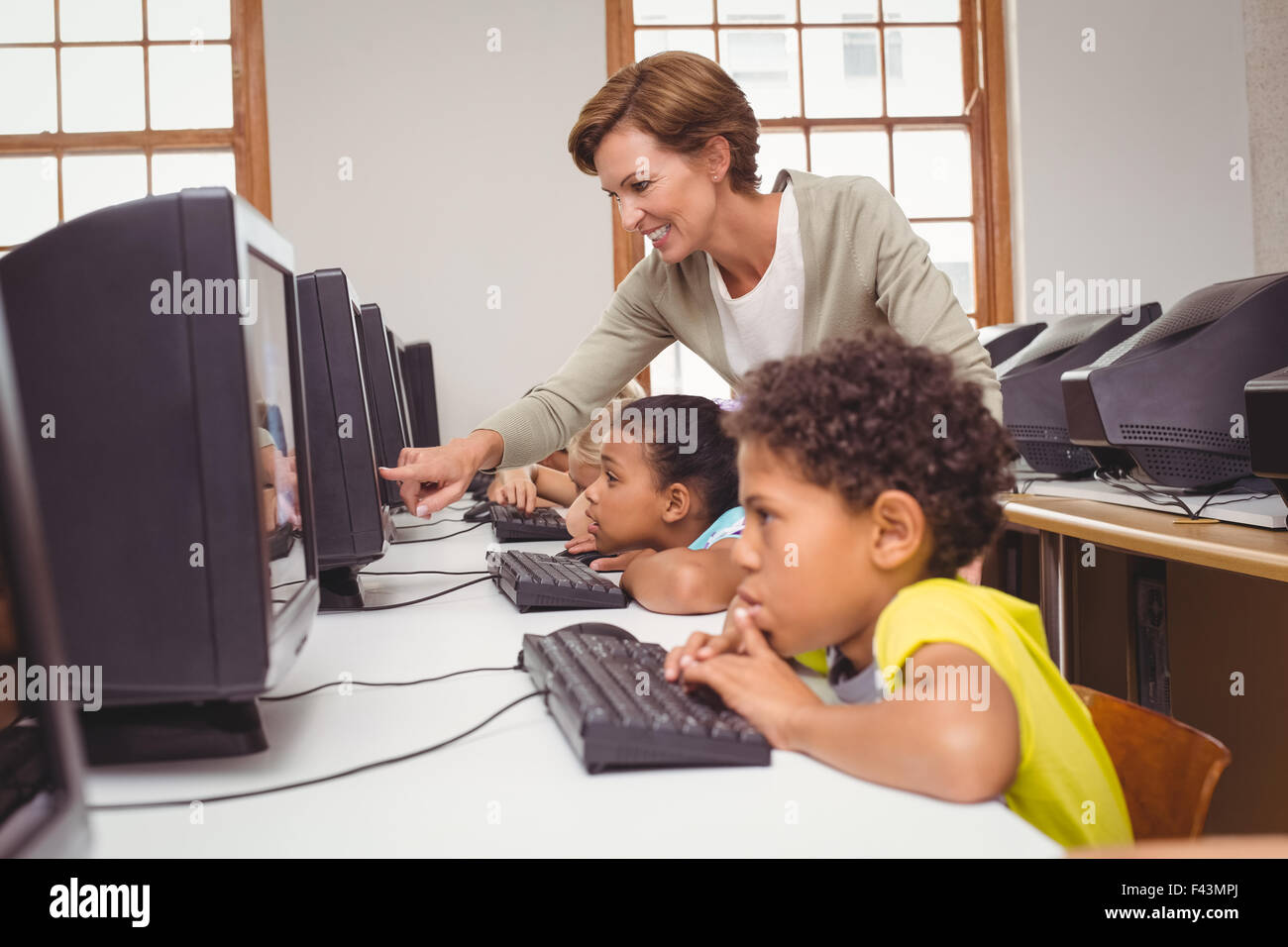 Cute pupils in computer class with teacher Stock Photo - Alamy