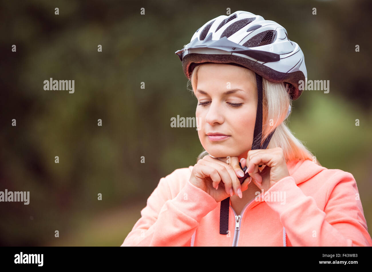 Woman fastening her bike helmet Stock Photo