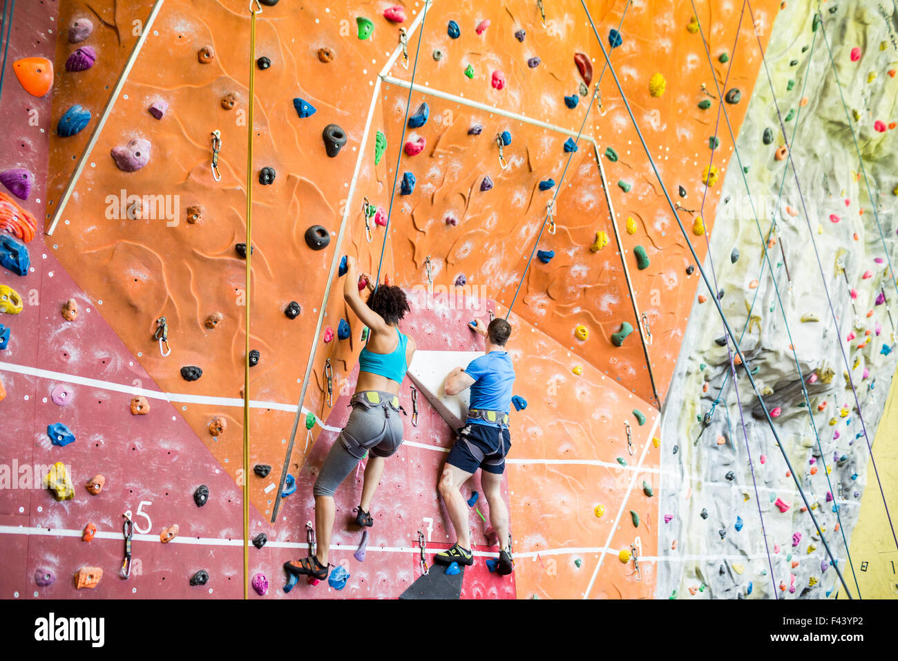 Fit couple rock climbing indoors Stock Photo