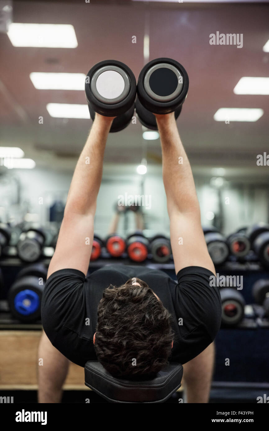 Man lifting dumbbell weights while lying down Stock Photo Alamy
