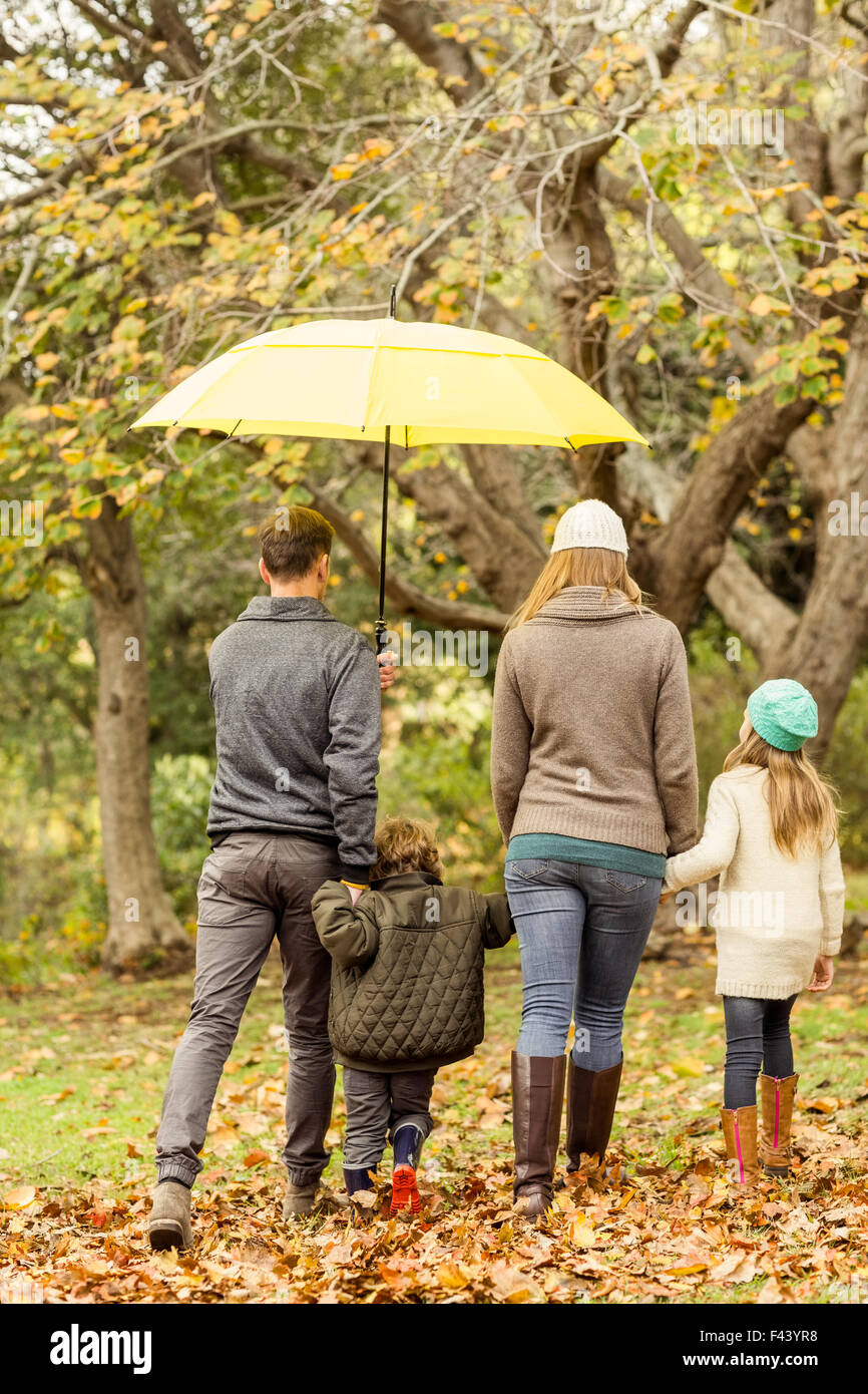 Rear view of young family under umbrella Stock Photo