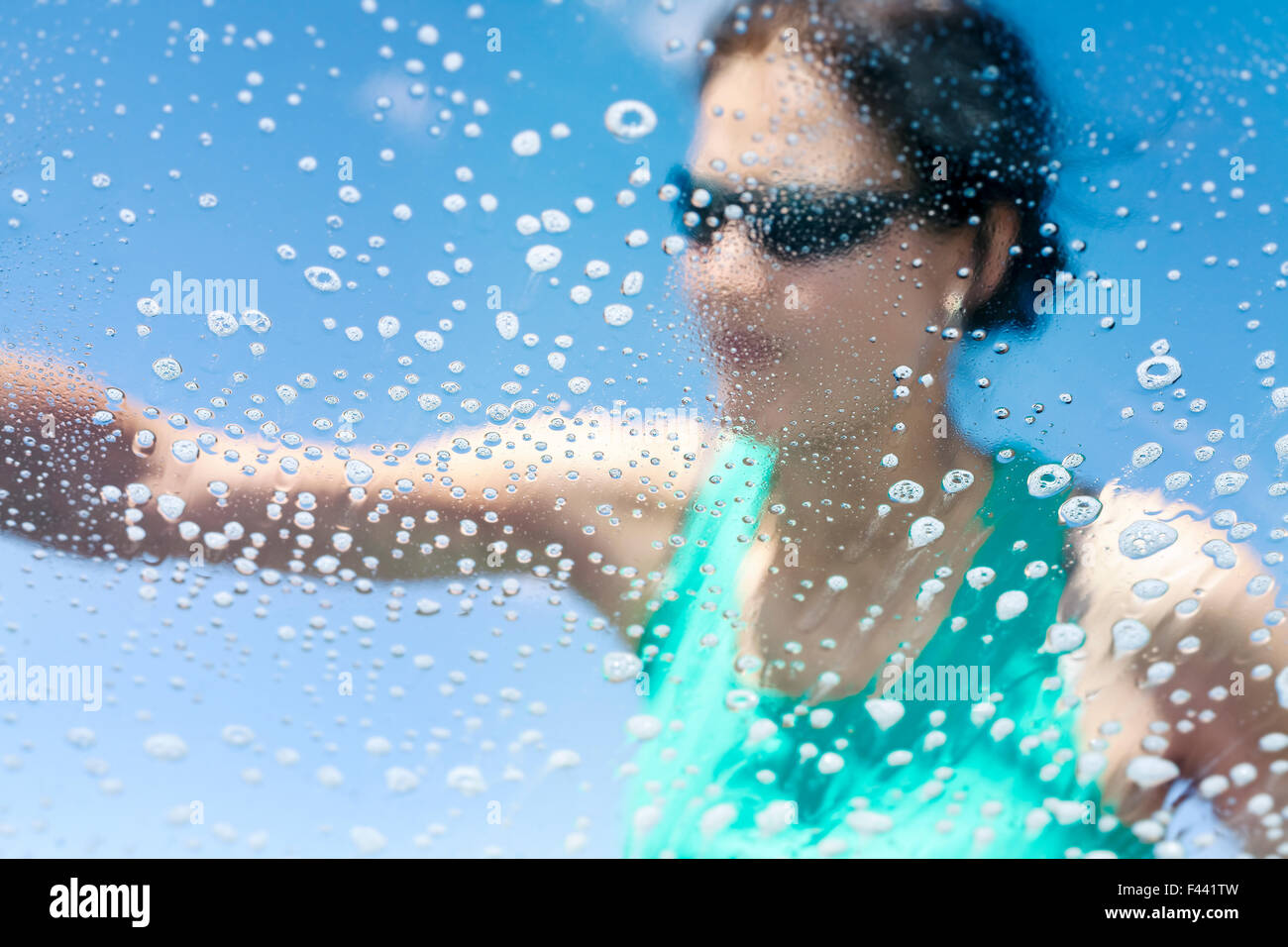 Blurred woman washing car window, soap bubbles from inside Stock Photo