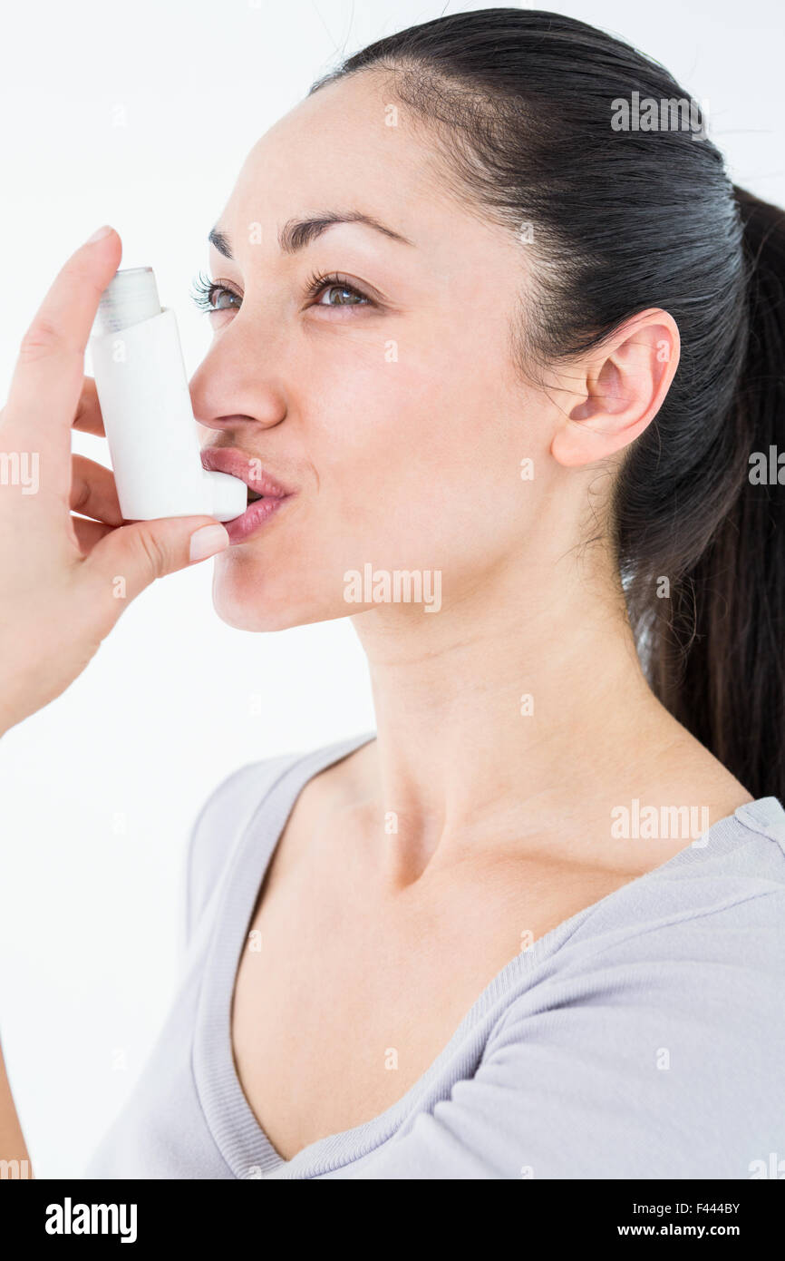 Asthmatic pretty brunette using inhaler Stock Photo - Alamy