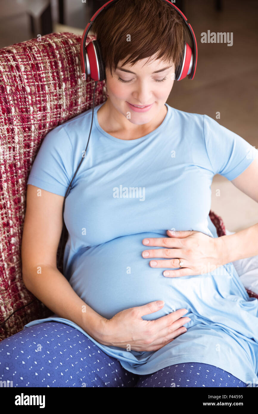Pregnant woman listening to music Stock Photo - Alamy