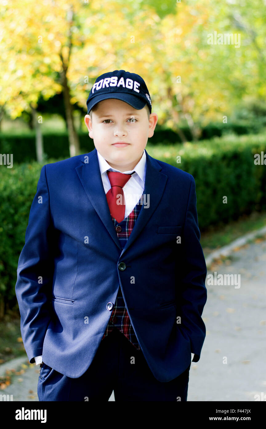 the school student in a suit in the fall near school, fall Stock Photo
