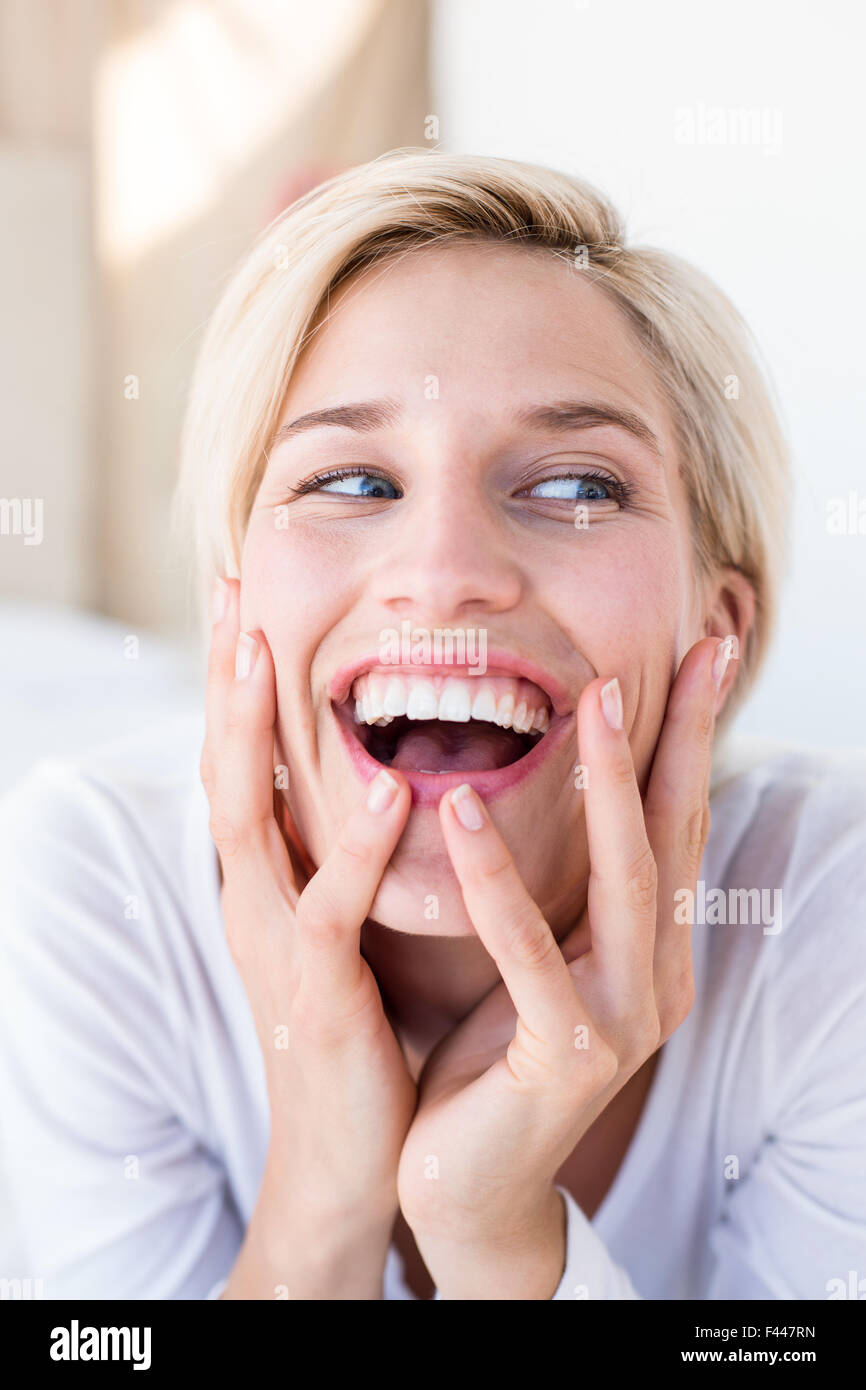 Smiling blonde woman lying on the bed Stock Photo Alamy