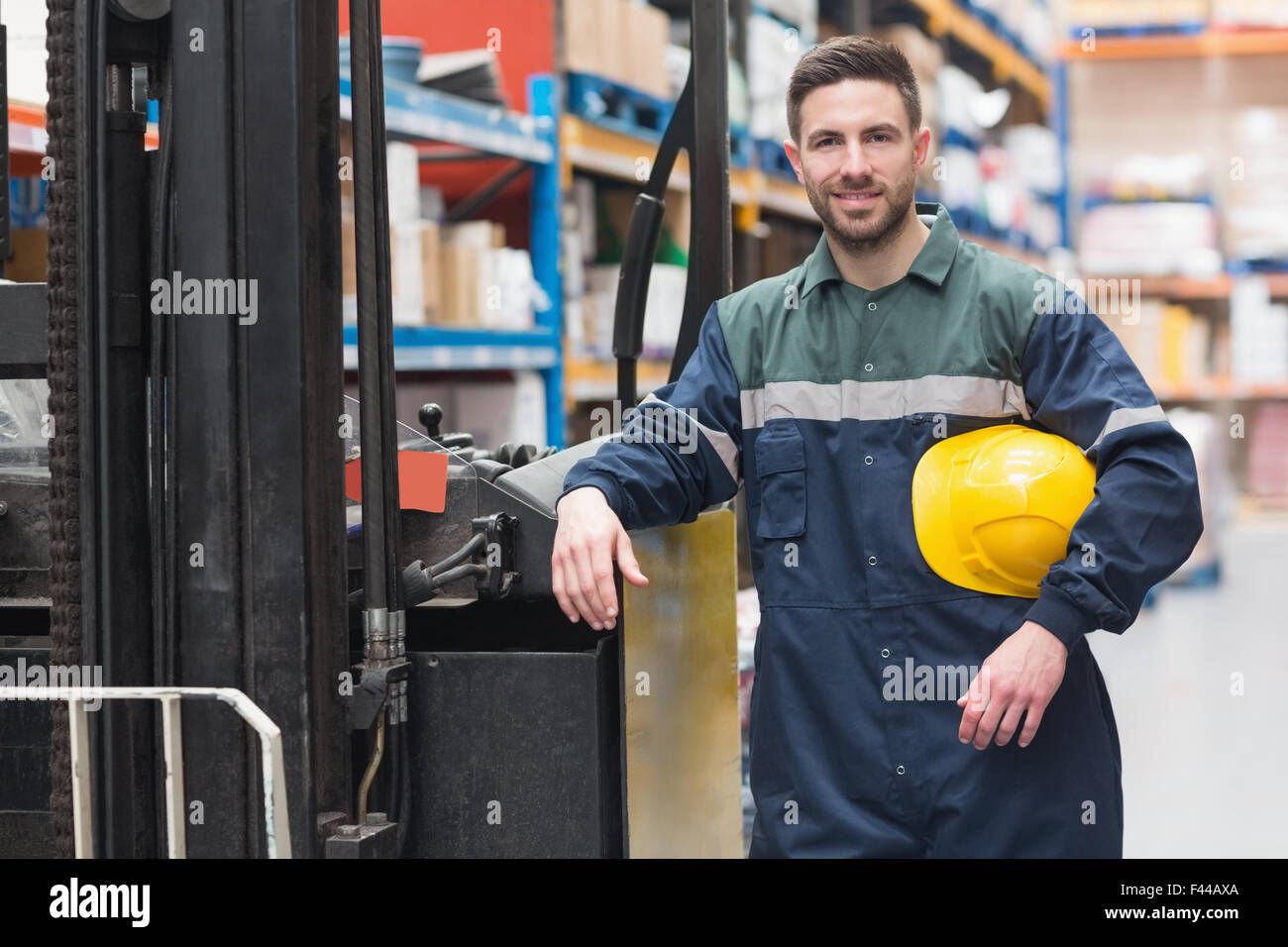 Manual worker leaning against the forklift Stock Photo