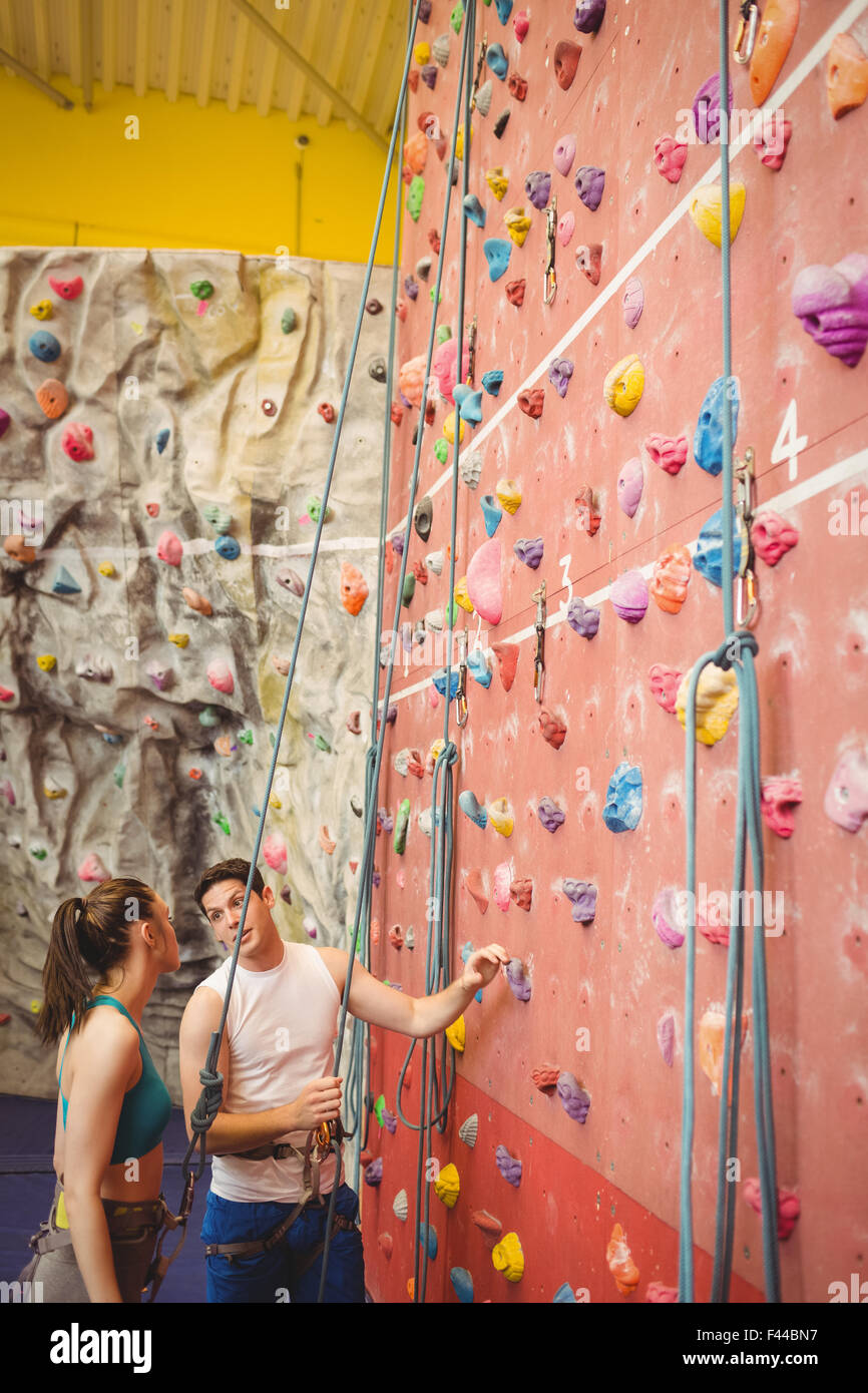 Instructor showing woman rock climbing wall Stock Photo Alamy