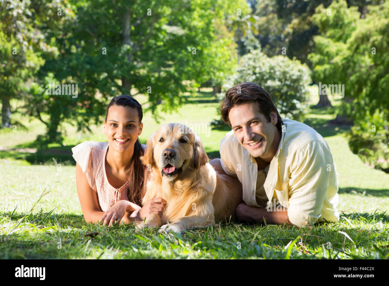 Happy couple with their dog in the park Stock Photo - Alamy