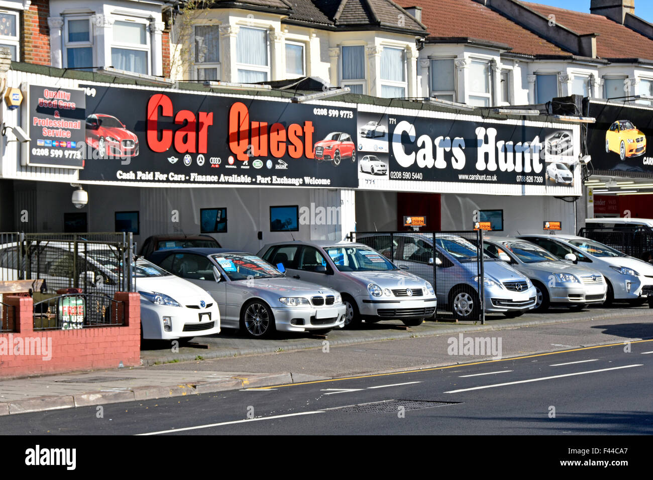 Second hand used cars for sale along ground floor house frontages Seven Kings Ilford East London England UK obscured number plates Stock Photo