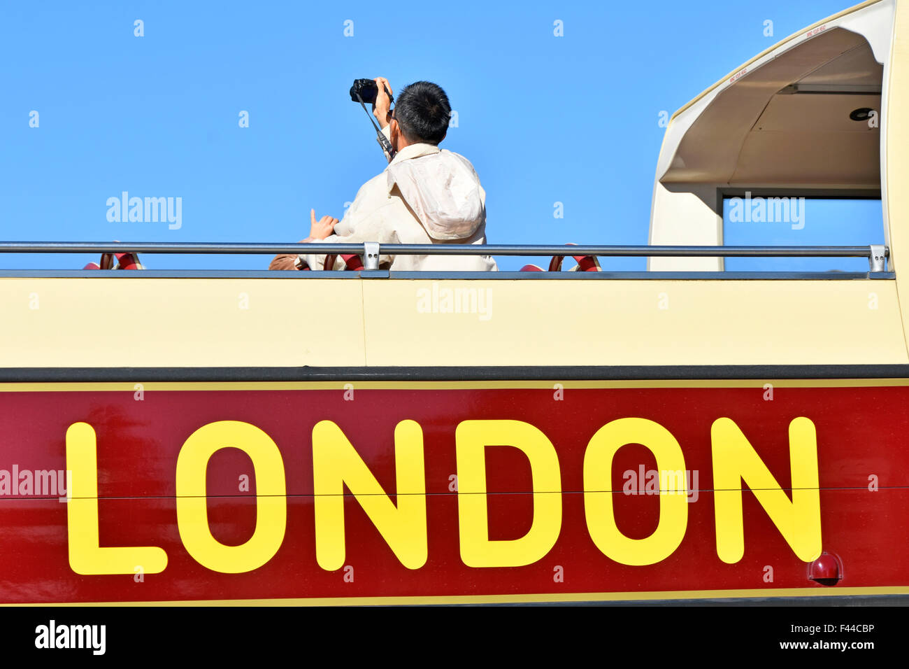 London tourist visitor photographing the sights from an open top tour bus in Trafalgar Square England UK Stock Photo