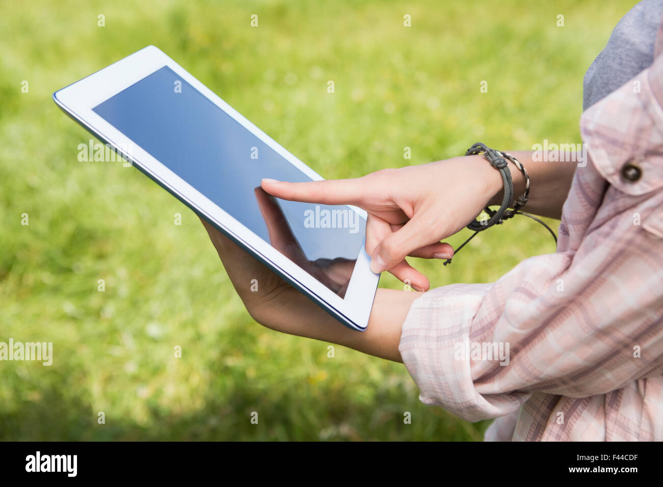 Woman using a tablet in the park Stock Photo - Alamy