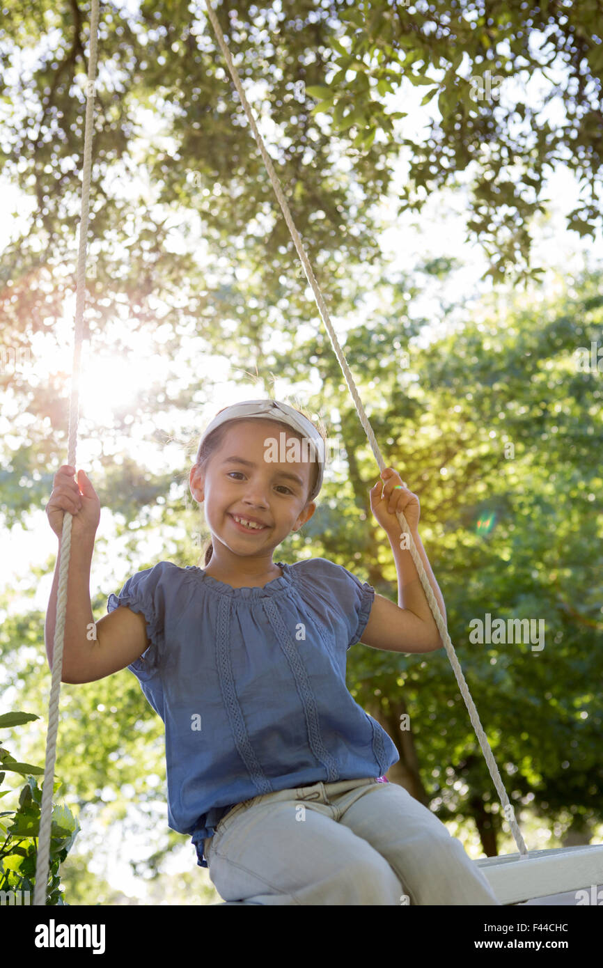 Happy little girl on a swing in the park Stock Photo - Alamy