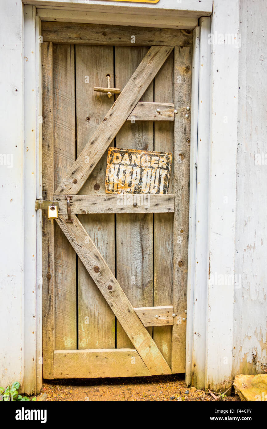 old wooden door with danger sign Stock Photo