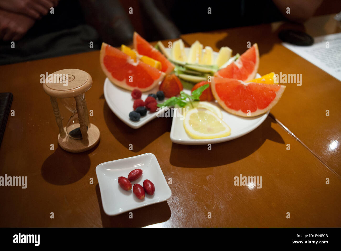 Miracle fruit with hour glass and citrus fruits viewed from above Stock Photo