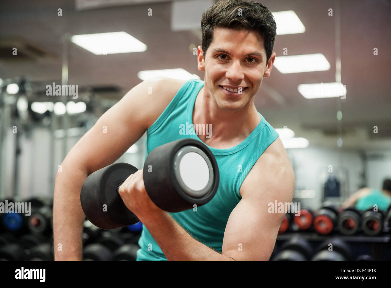 Man lifting dumbbell weight while sitting Stock Photo Alamy
