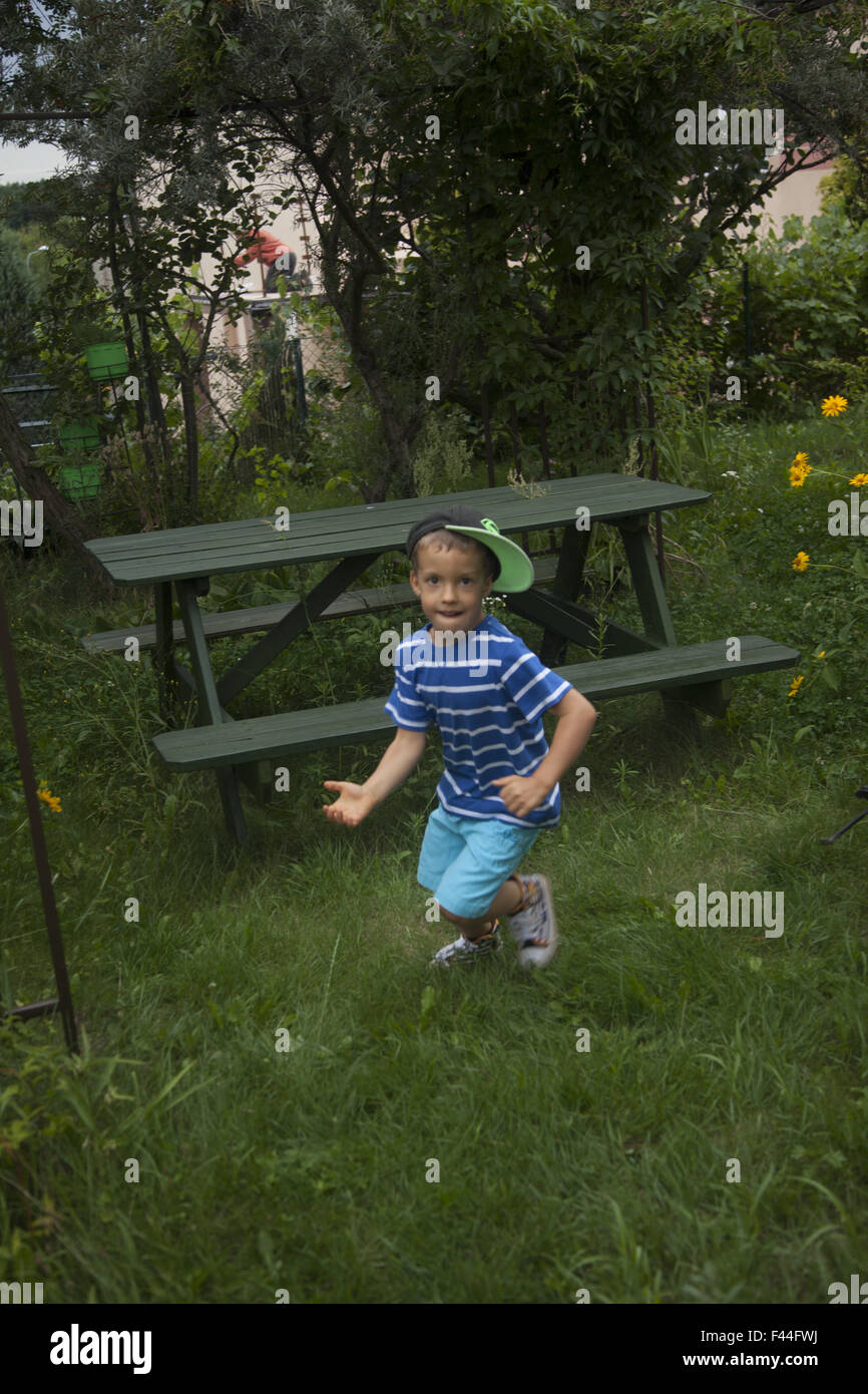 Young boy plays alone at home in the backyard in Zielona Gora, Poland. Stock Photo