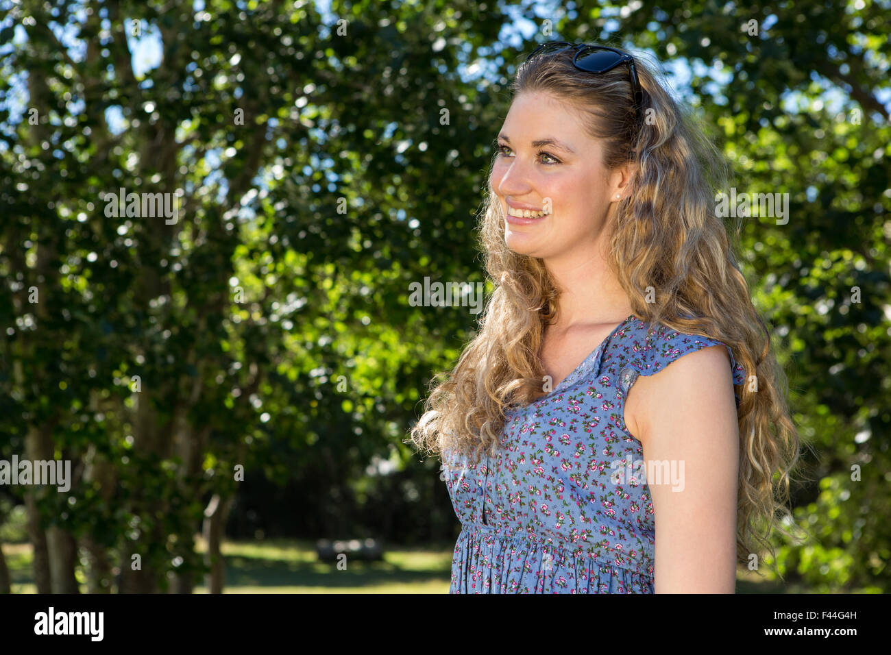 Pretty blonde smiling in the park Stock Photo - Alamy