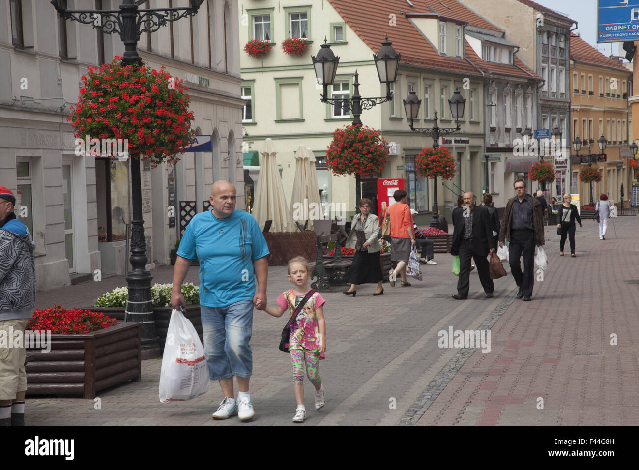 Grandpa walks with granddaughter in the town center in Zielona Gora, Poland Stock Photo