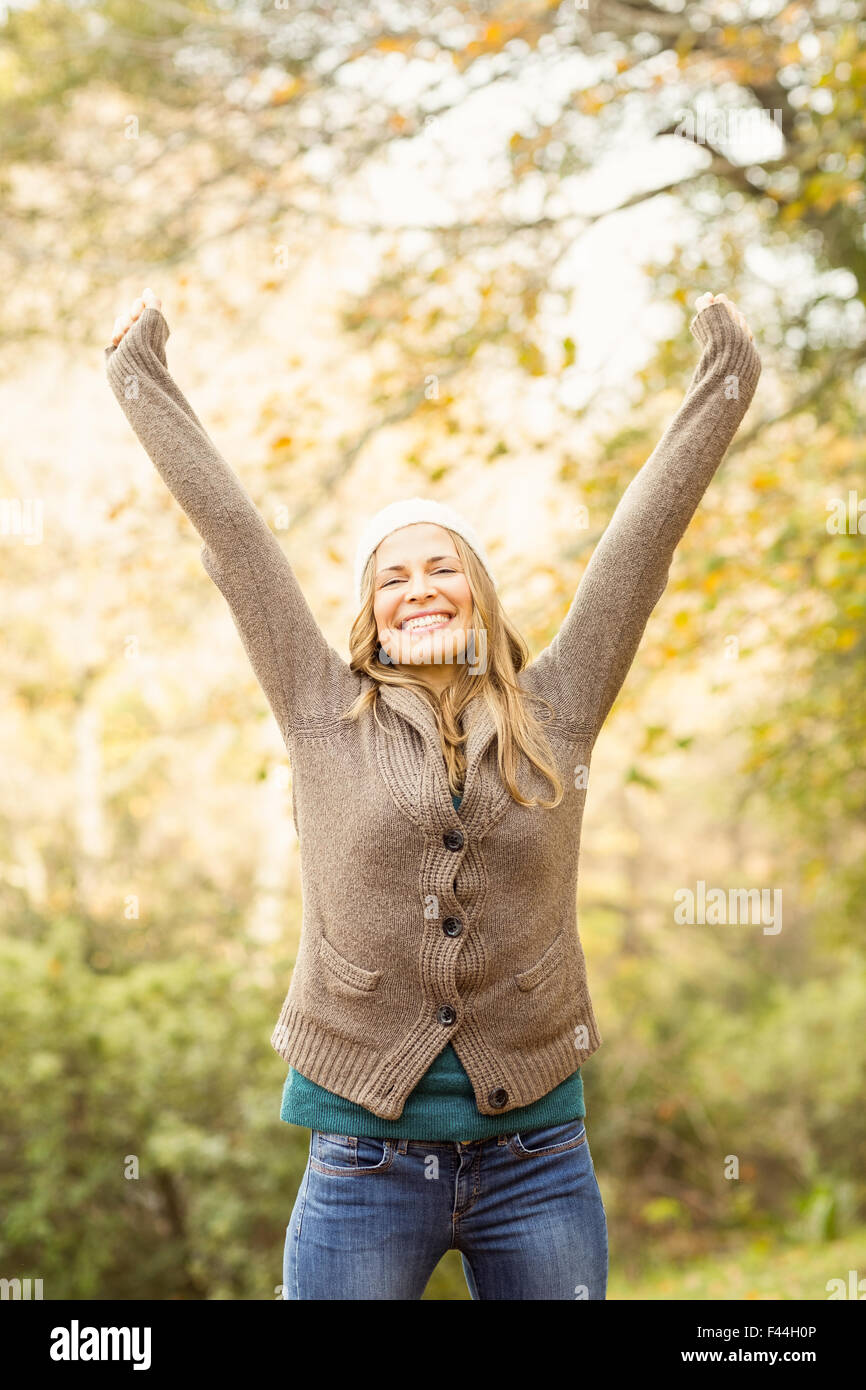 Smiling pretty woman with arms raised Stock Photo