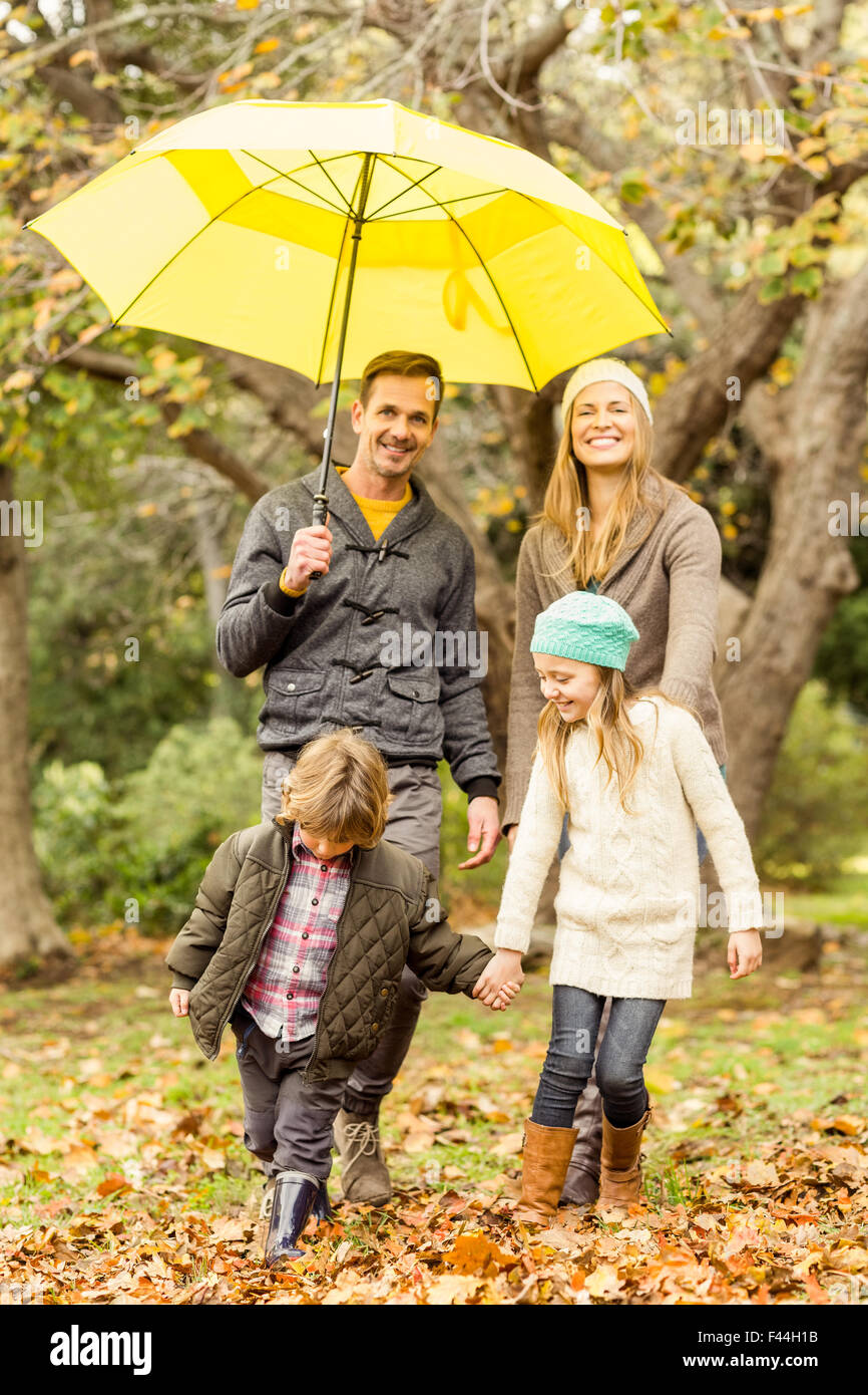 Smiling young family under umbrella Stock Photo