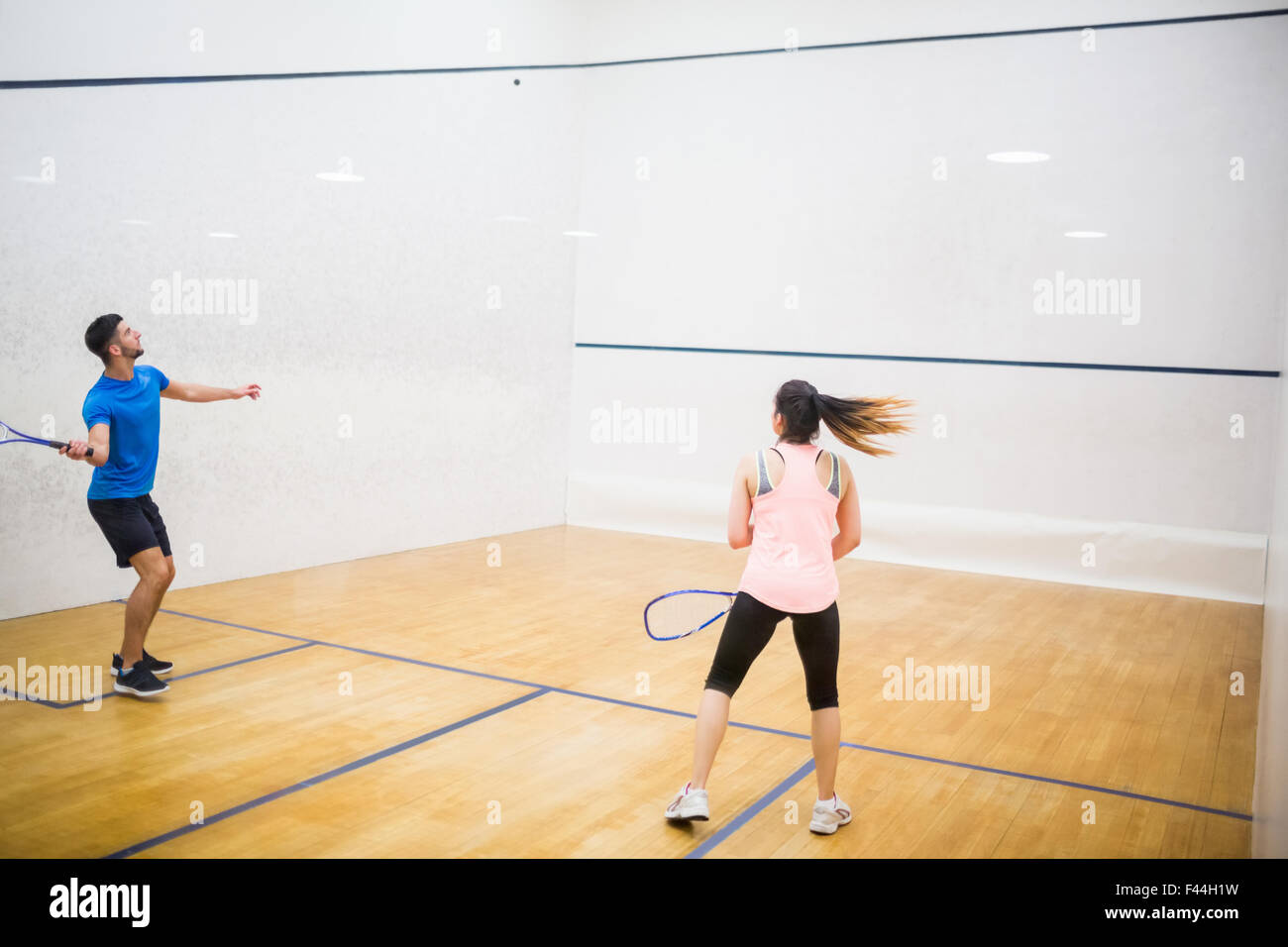 Competitive couple playing squash together Stock Photo